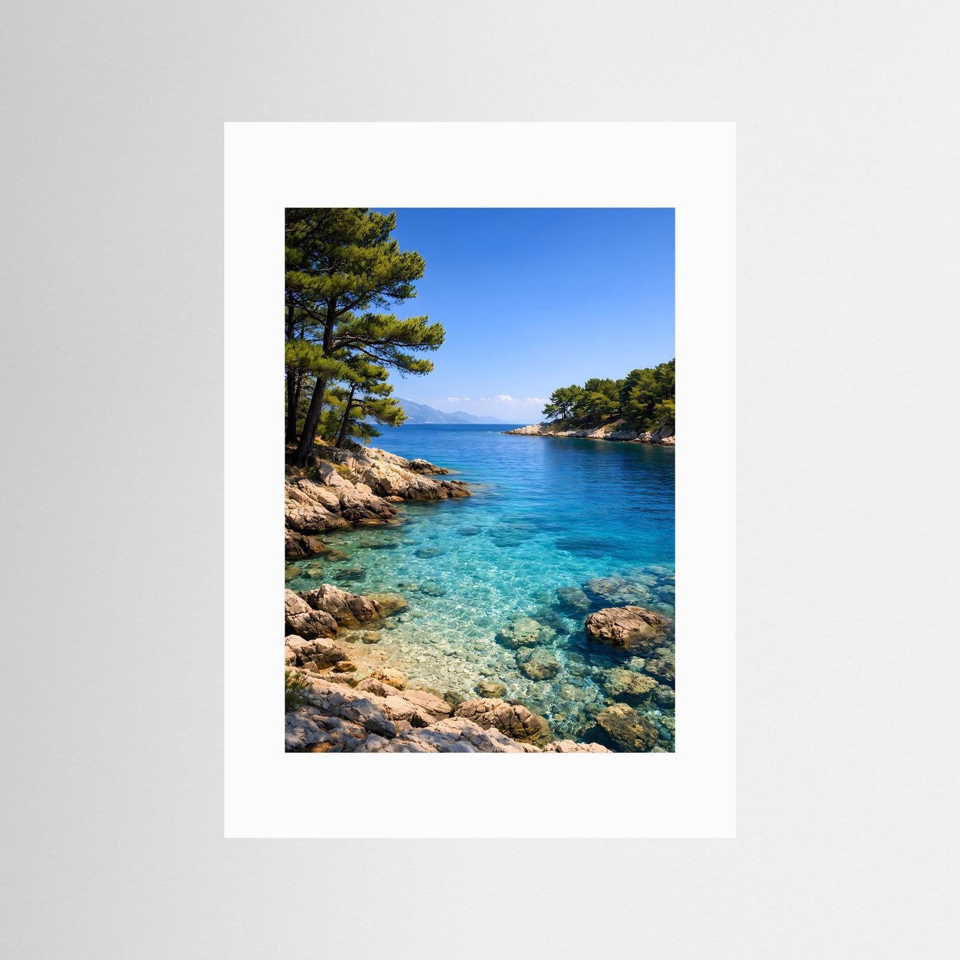 Küstenposter im Hochformat mit türkisblauem Meer, Felsen und Pinien im weißen Passepartout
