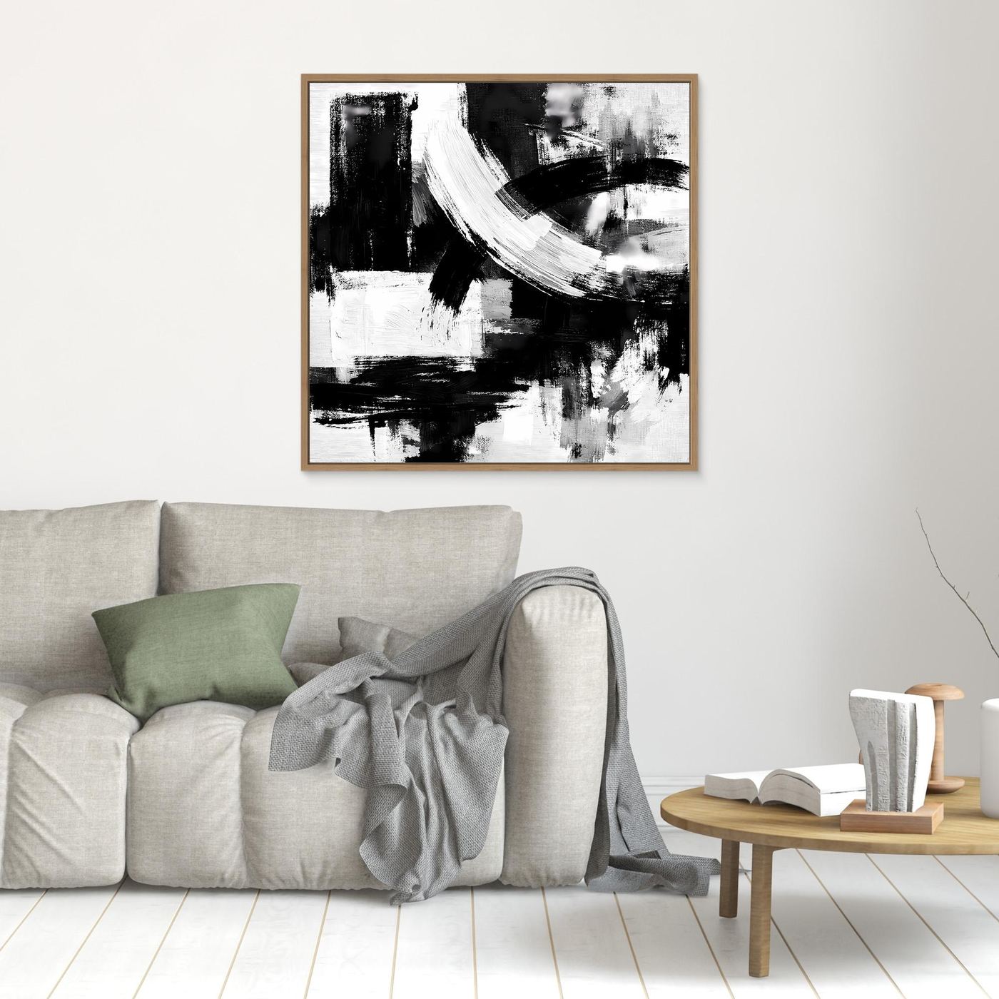 Abstract canvas wall art with black and white brush strokes, in a light wood frame