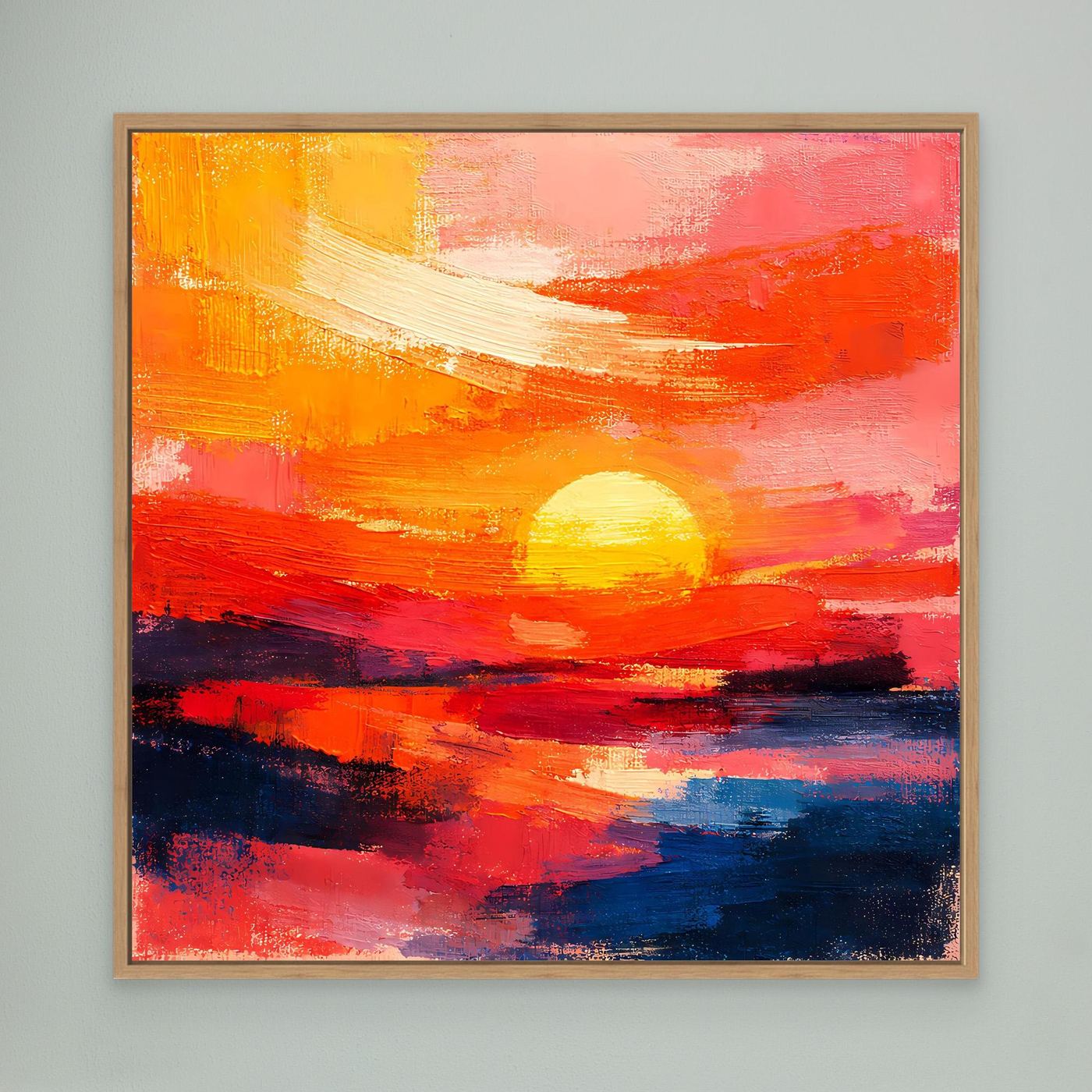 Abstract sunset wall art in a light wood frame, with glowing sun and ocean colors in red and blue.