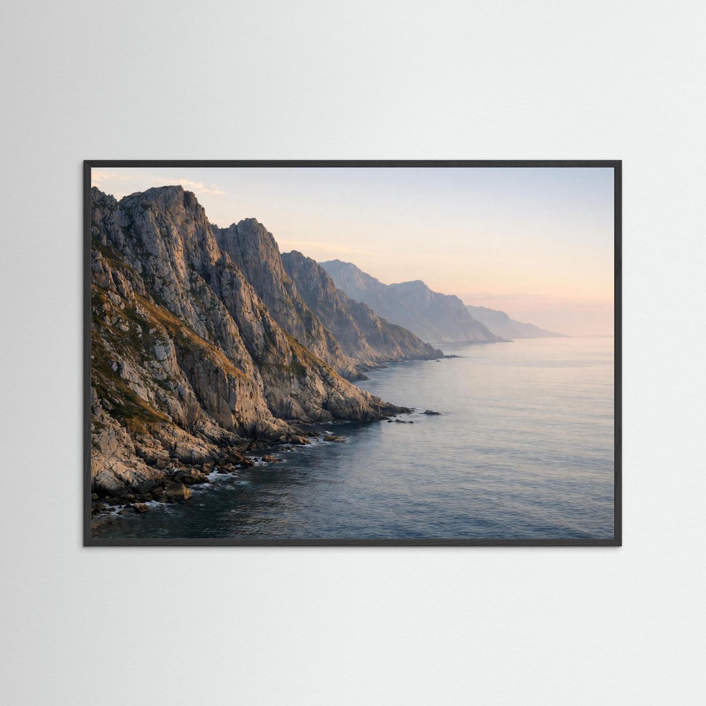 Gerahmtes Poster im Querformat: Panorama-Felsküste am Meer im Abendlicht, schwarzer Rahmen