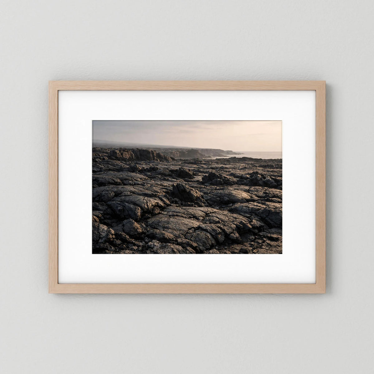 Gerahmtes Querformat-Wandbild mit Lavafeldern an der Küste, Holzrahmen natur