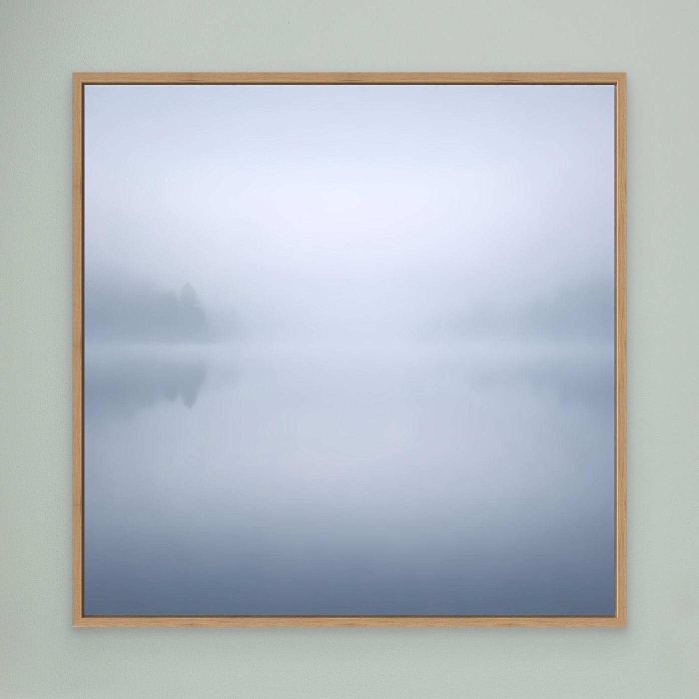 Leinwandbild mit Nebelsee-Motiv, blass blau-grau, Rahmen aus hellem Holz