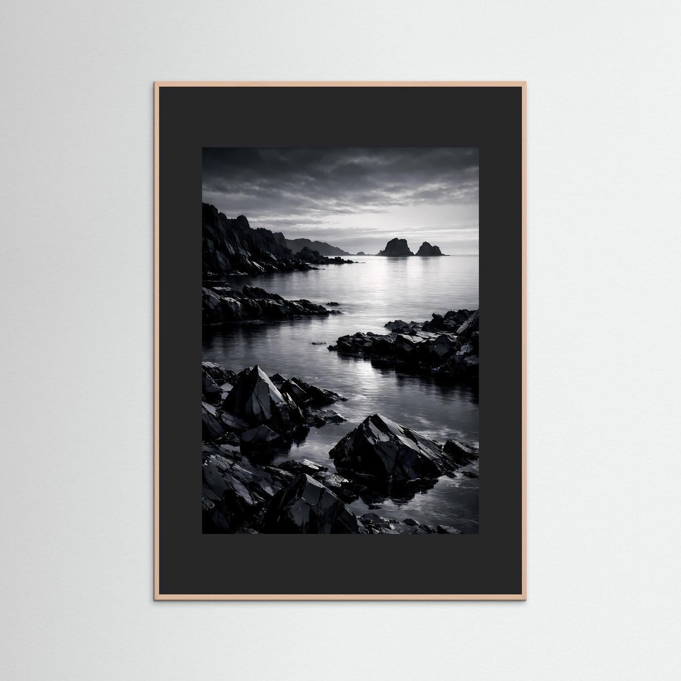 Gerahmtes Schwarzweiß-Foto einer Felsküste am Wasser mit braunem Holzrahmen