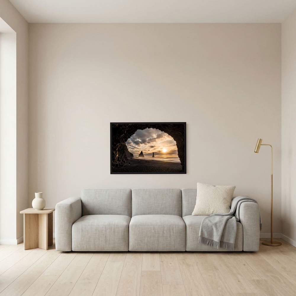 Wandposter im schwarzen Rahmen: Felsbogen am schwarzen Sandstrand im Sonnenuntergang