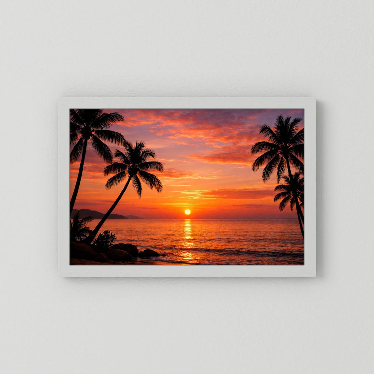 Wandbild mit Sonnenuntergang über dem Meer und Palmen-Silhouetten im weißen Rahmen