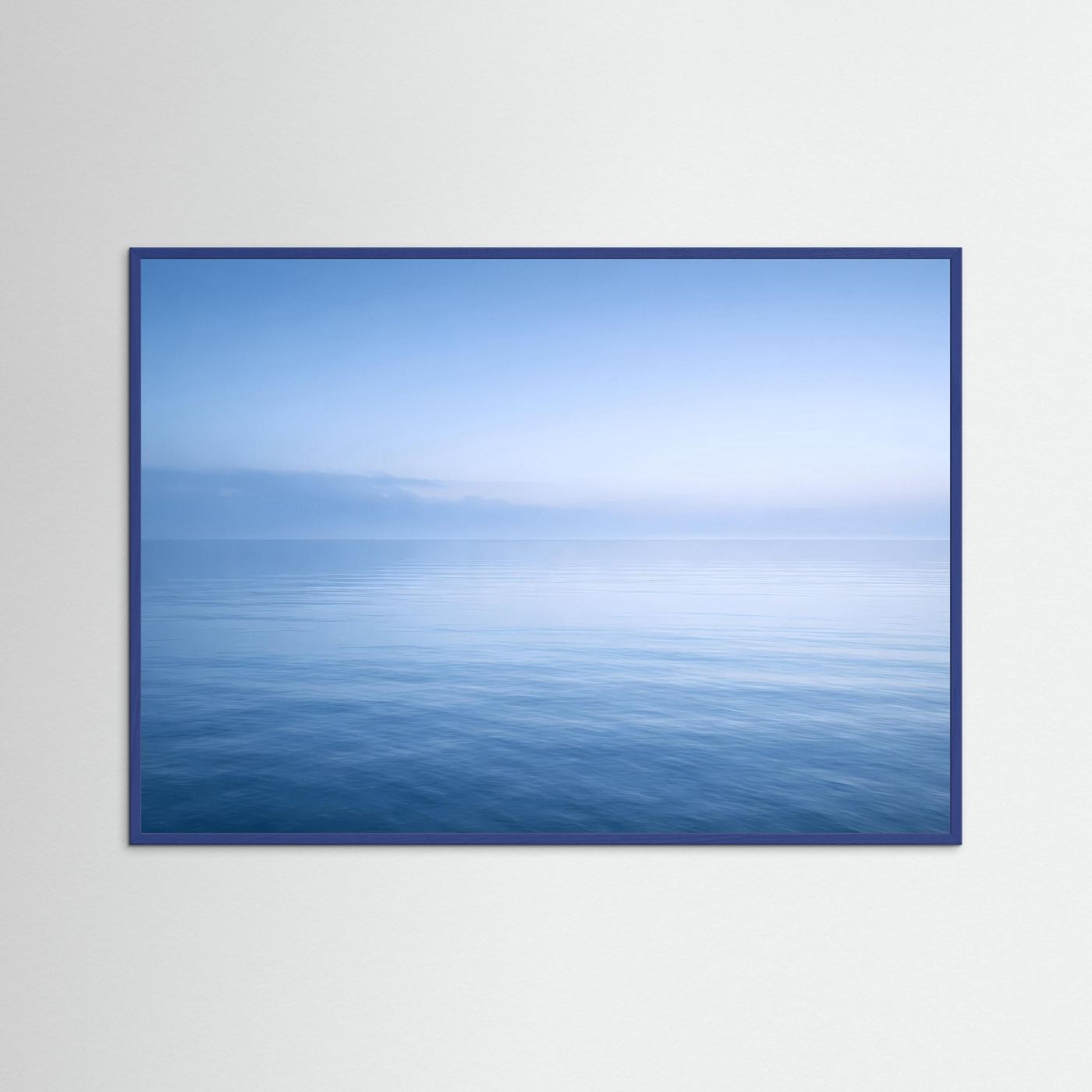 Meer-Wandbild Querformat mit blauem Holzrahmen, sanfter Horizont über ruhiger Wasserfläche.