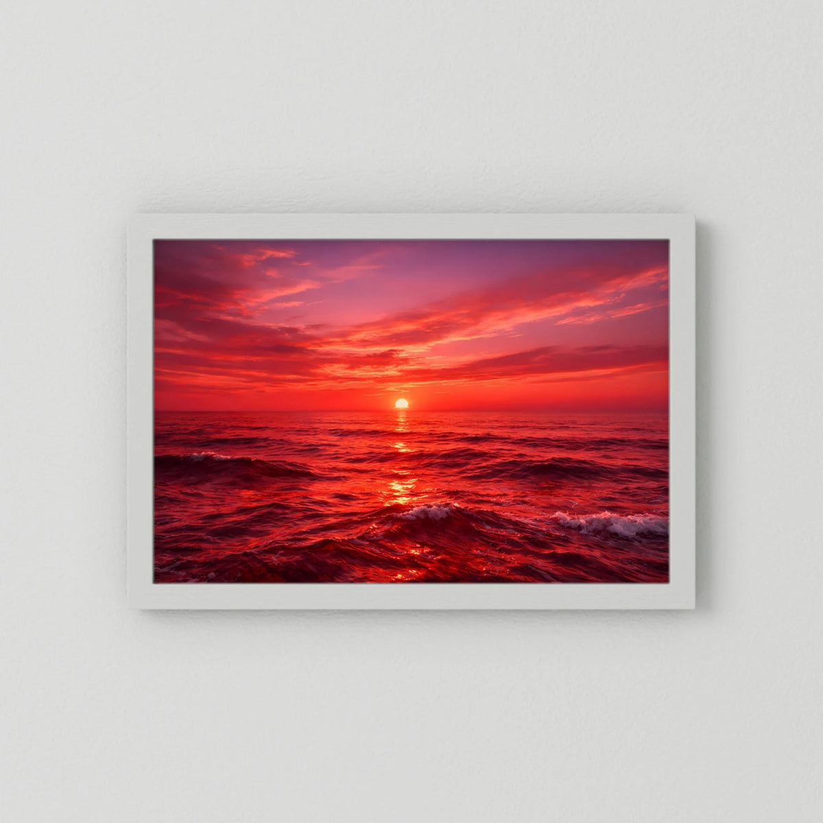 Querformatiges Wandbild mit Sonnenuntergang über dem Meer im weiß eingefassten Rahmen