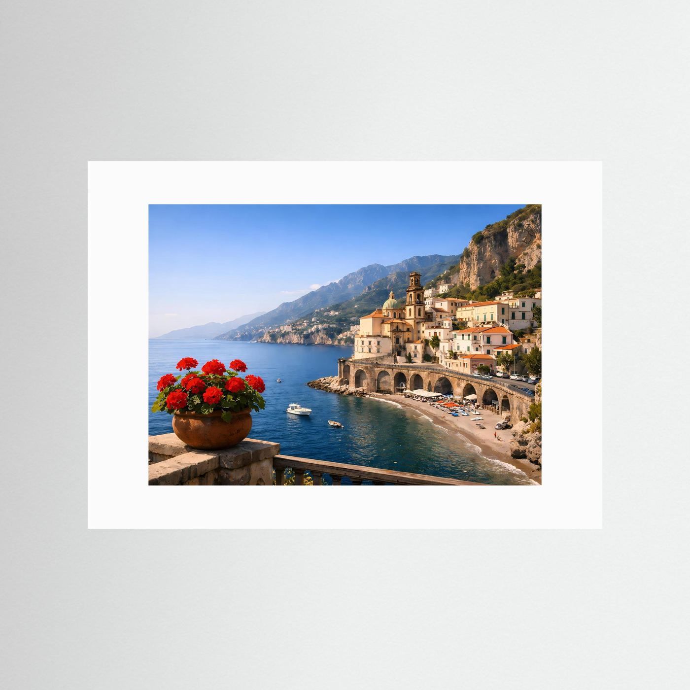 Panorama-Poster mit weißem Passepartout: Küstenort, Kirche, Bögen, Strand und rote Blumen.