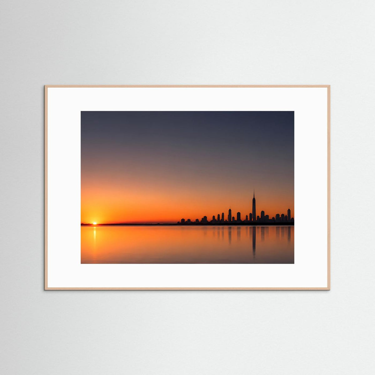 Poster im Querformat mit Stadtsilhouette bei Sonnenuntergang, heller Holzrahmen