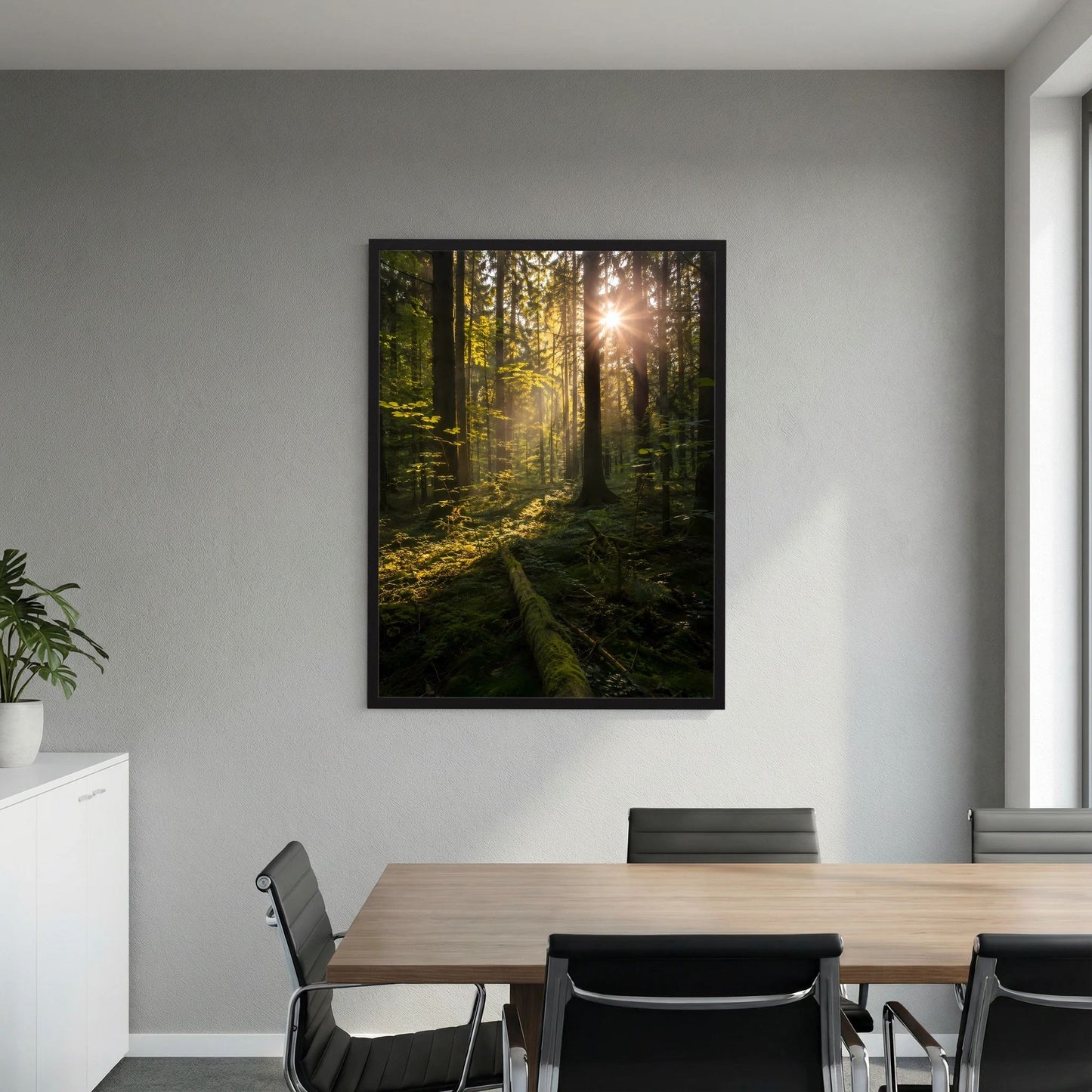 Hochformat-Poster mit Waldmotiv und Sonnenstrahlen an der Wand, schwarzer Rahmen