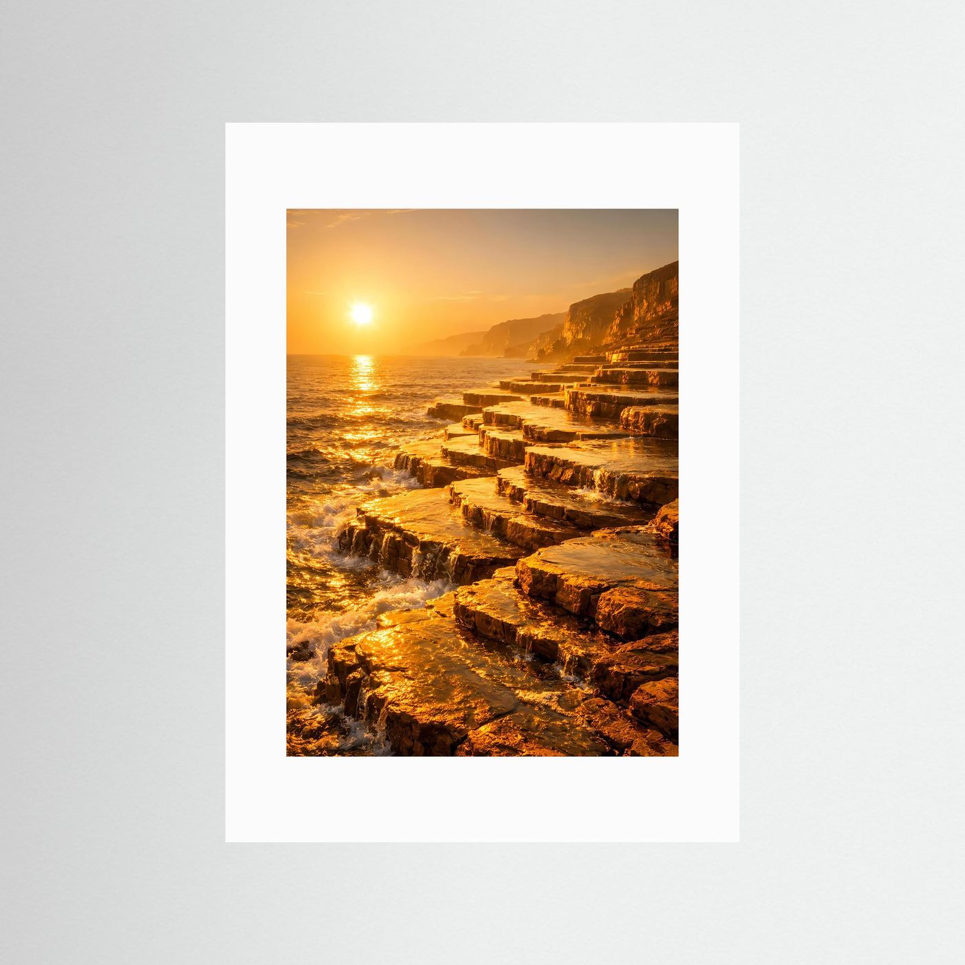 Hochformatiges Küstenposter mit weißem Rand, goldener Sonnenuntergang und Felswellen