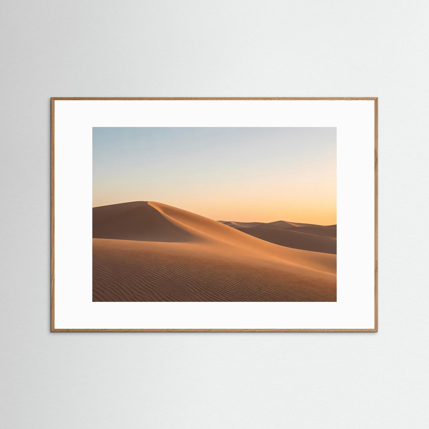 Gerahmtes Wüstenbild mit goldenen Dünen im Sonnenuntergang, hellbrauner Holzrahmen