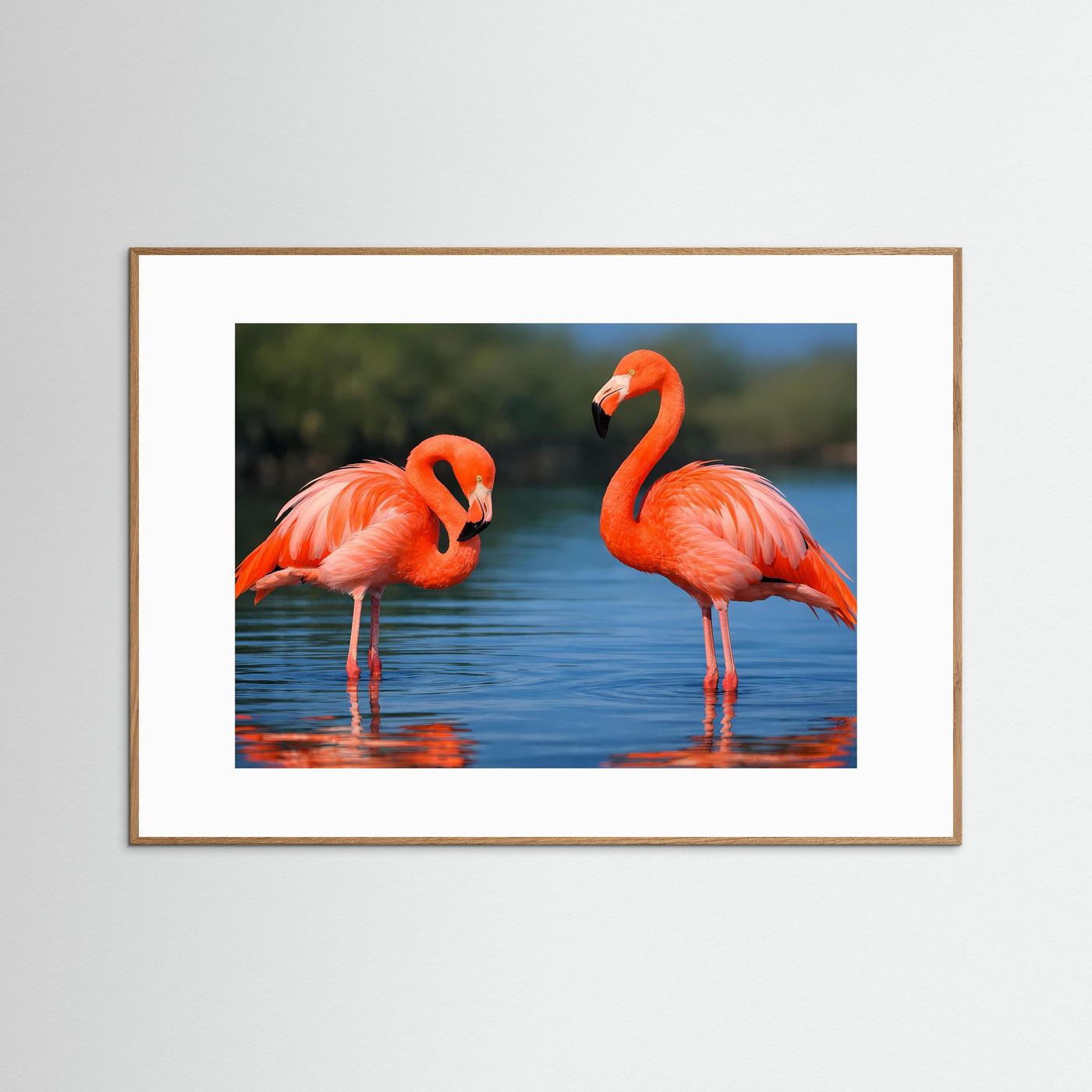 Poster mit zwei rosa Flamingos im Wasser, mit Holzrahmen in Naturton und weißem Rand.