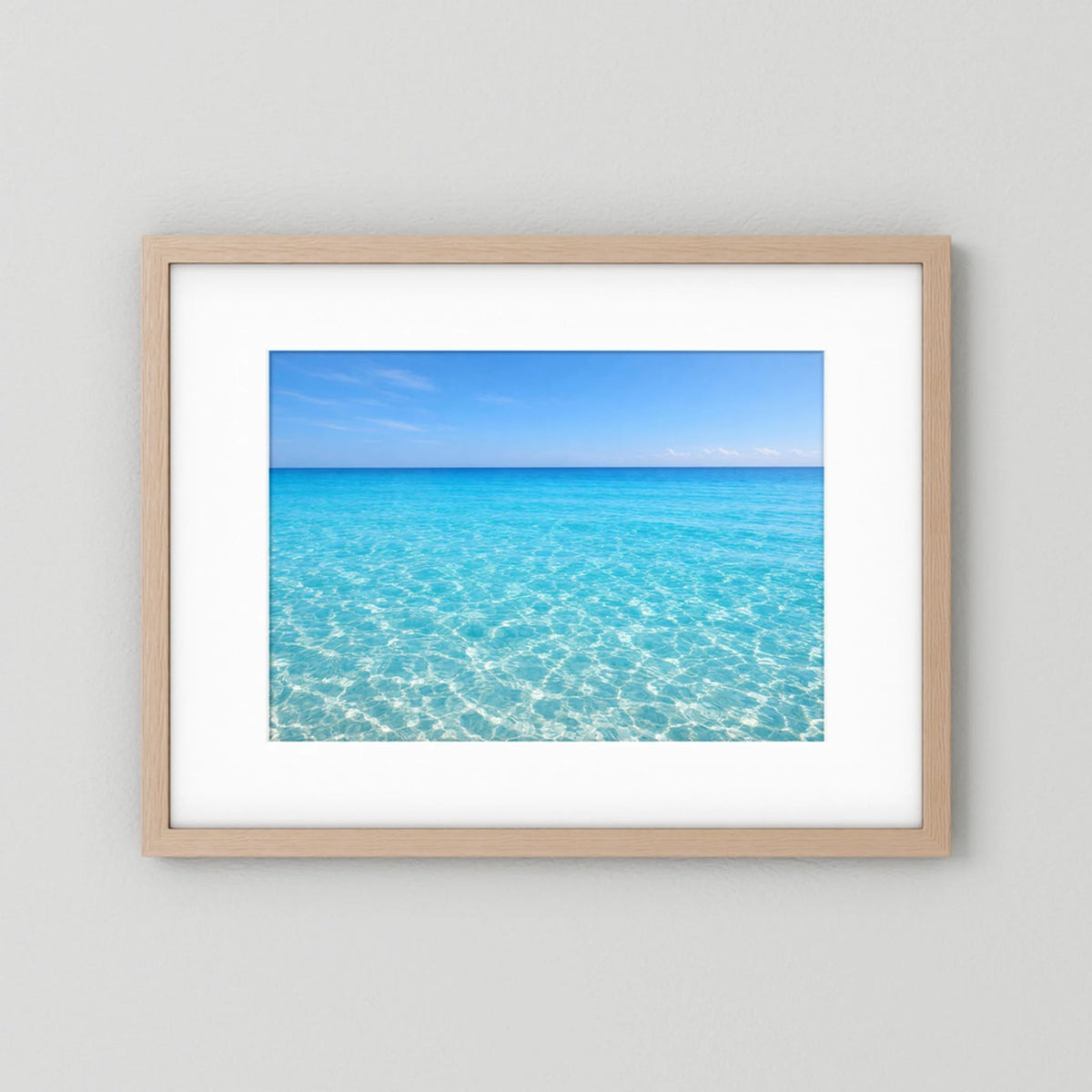 Wandbild im Querformat mit Rahmen aus hellem Holz und blauem Meerwasser-Motiv