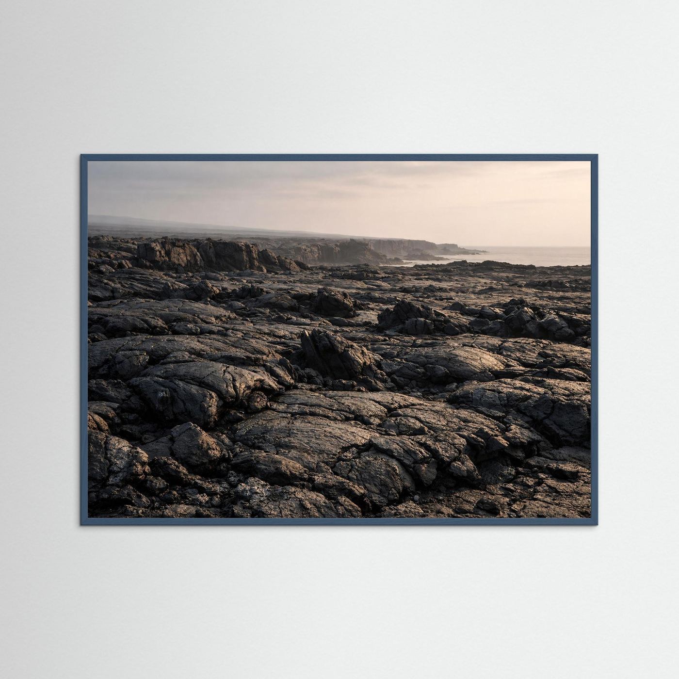 Wandbild mit blauem Rahmen: Lavafelder an der Küste, schwarz-graue Vulkangesteine