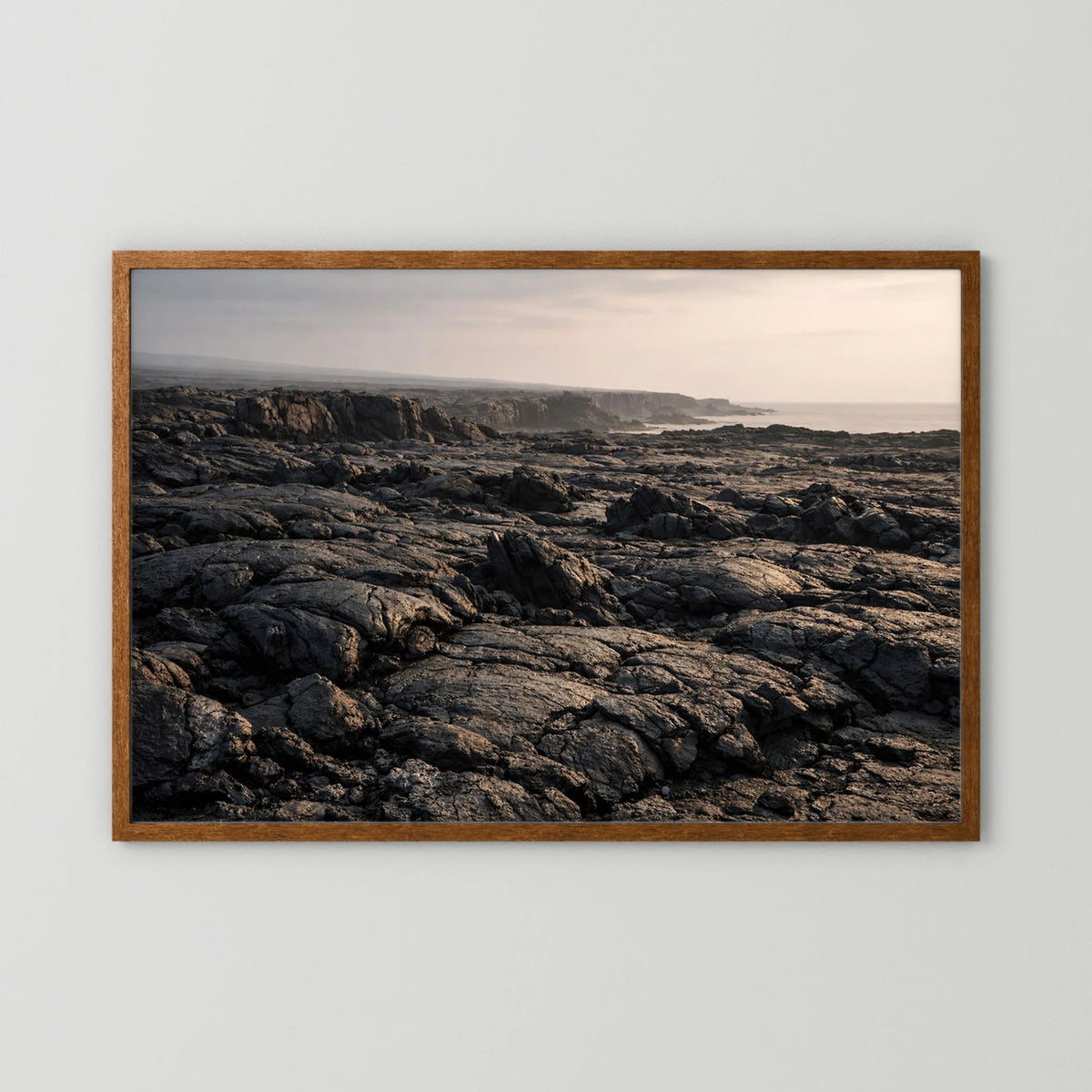 Querformat-Wandposter mit Lavafelsen an der Küste im braunen Holzrahmen