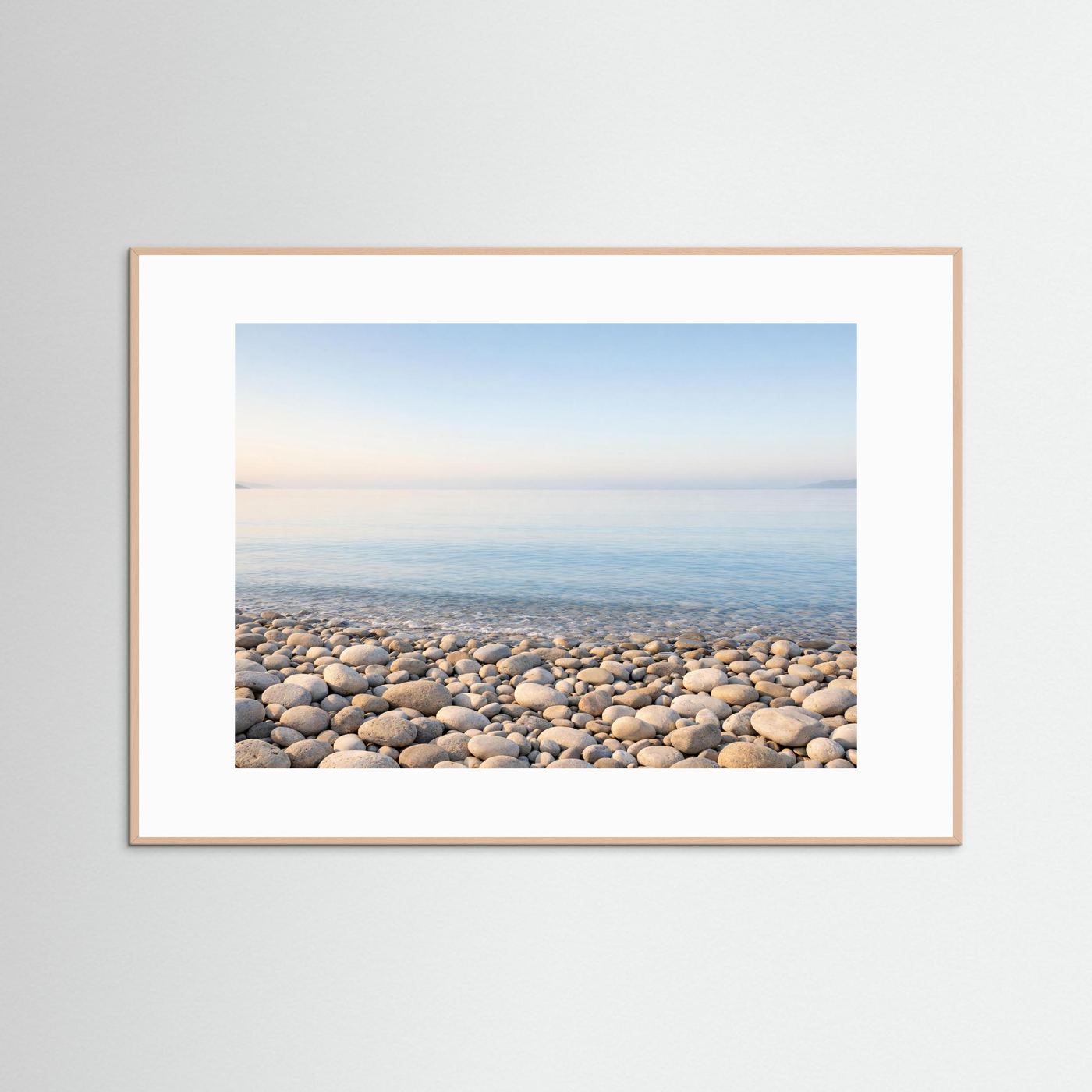 Küsten-Panorama-Poster mit Kiesstrand und ruhigem Meer, hellbrauner Rahmen