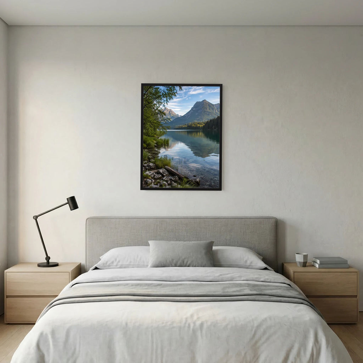Gerahmtes Poster im Hochformat: klarer Bergsee mit Ufersteinen, Wald und Berggipfel