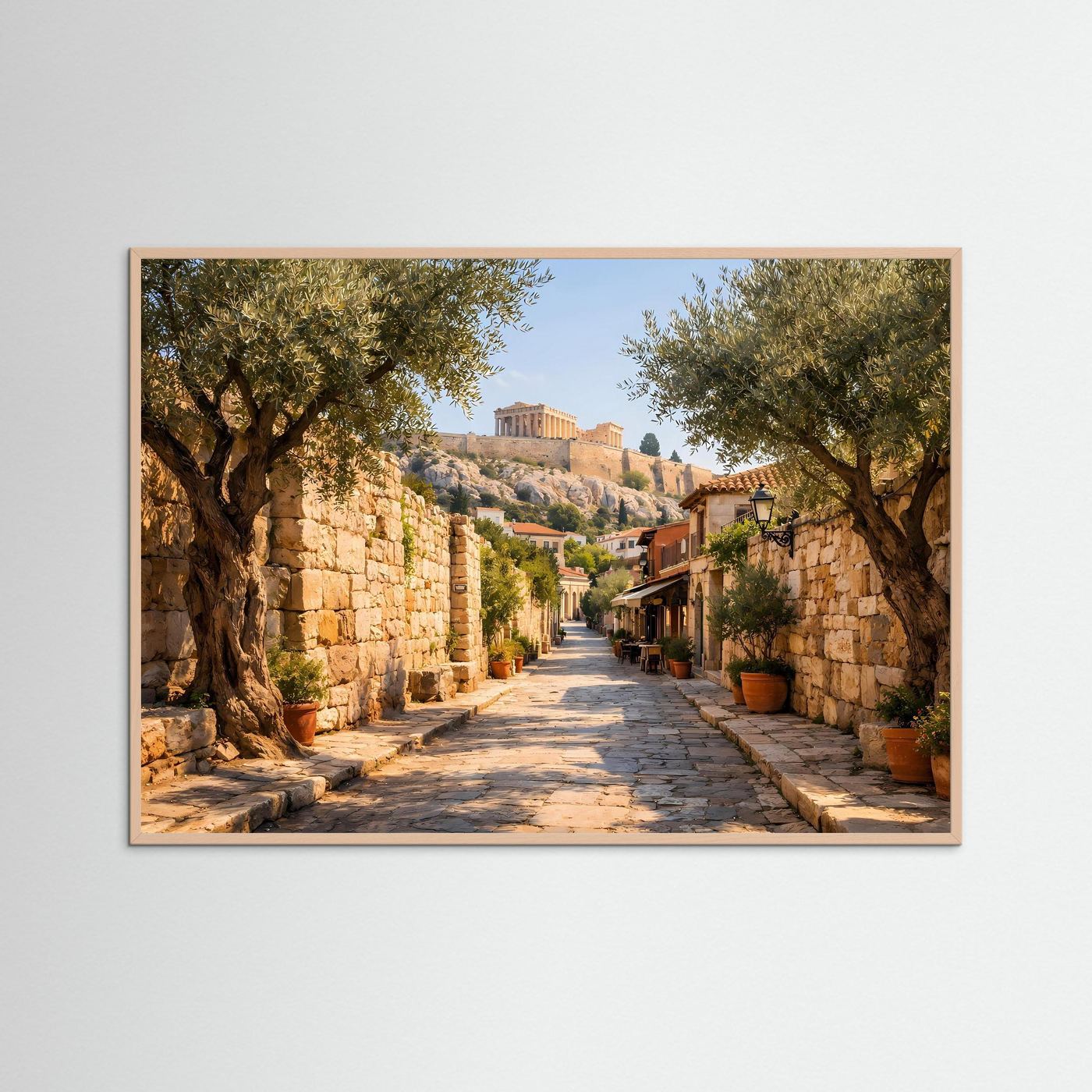 Wandbild mit mediterraner Gasse, Olivenbäume und Steinstraße, beiger Rahmen.