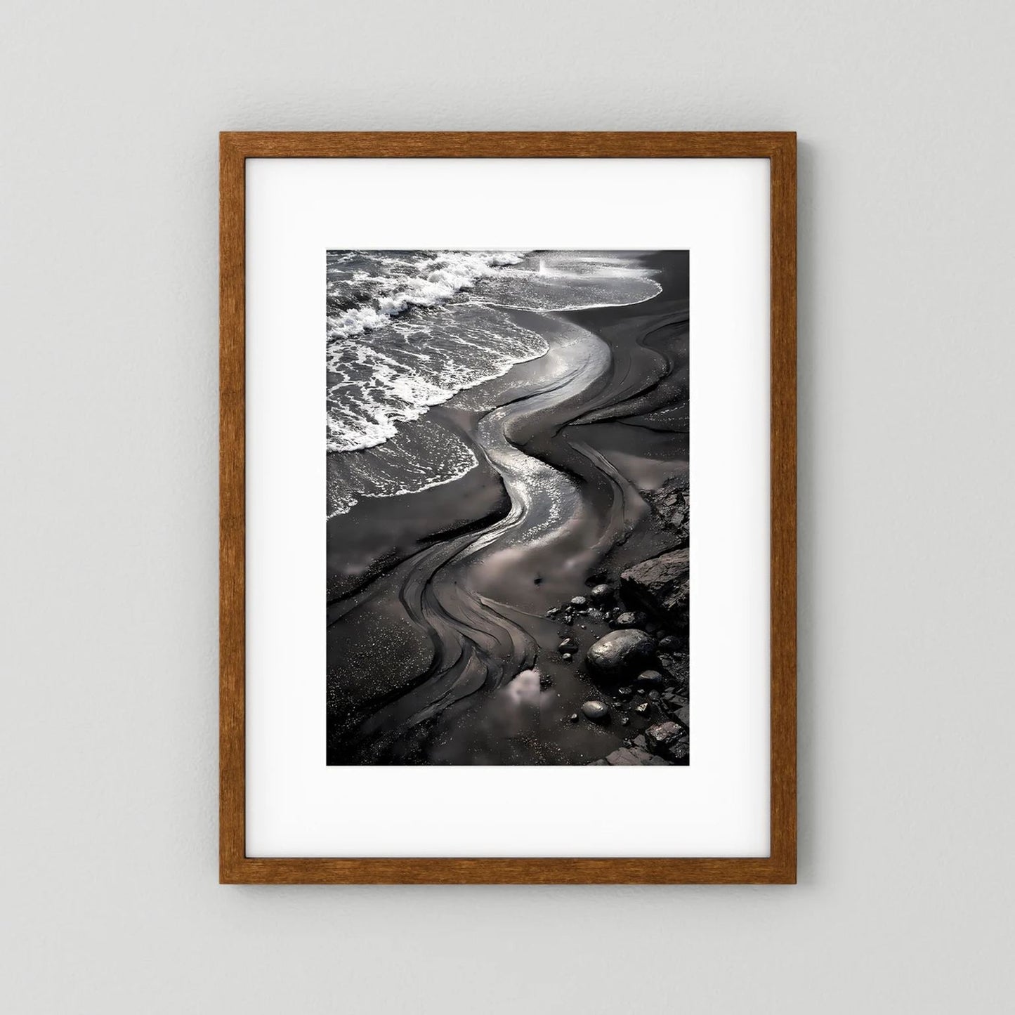 Strandposter mit schwarzem Sand und Meereswellen, brauner Holzrahmen mit weißem Rand