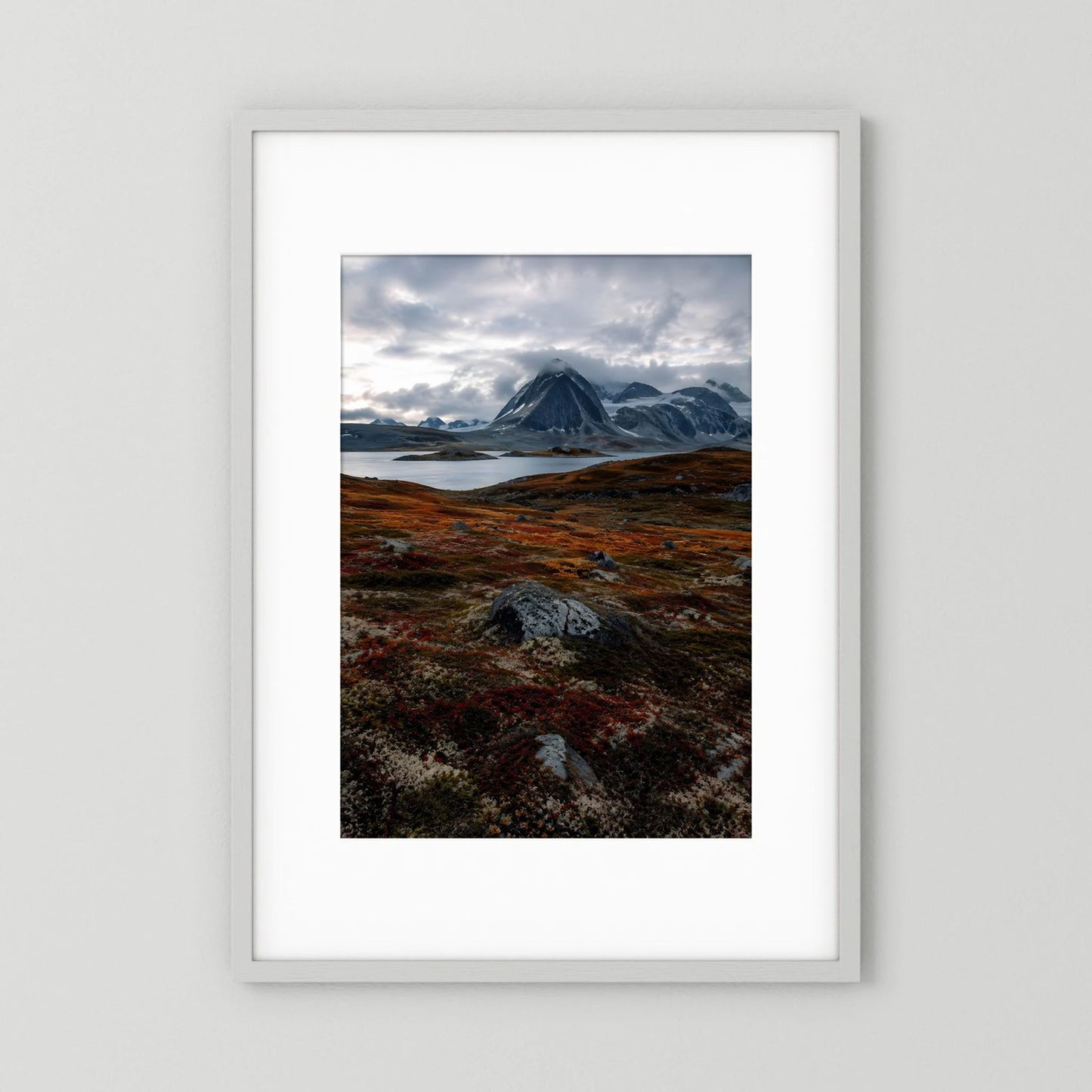 Gerahmtes Poster mit dramatischer Berglandschaft: Berge grau, Himmel dunkel, Akzente Rostrot