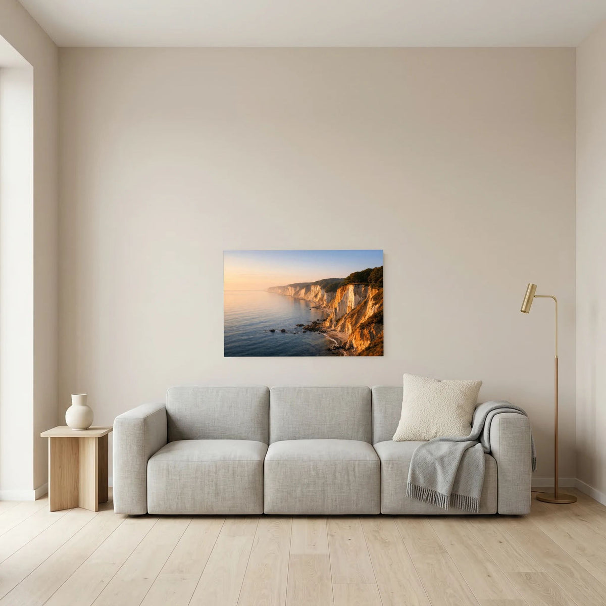 Wandbild mit Küstenfelsen, Strandabschnitt und Meer im Sonnenaufgang-Licht