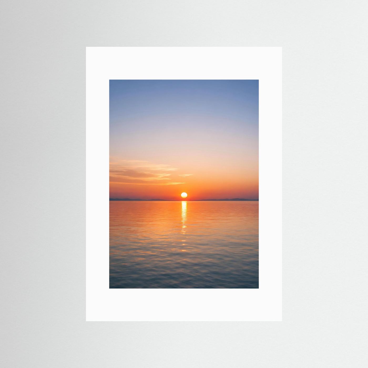 Hochformatiges Wandbild mit Sonnenuntergang über dem Meer im weißen Passepartout