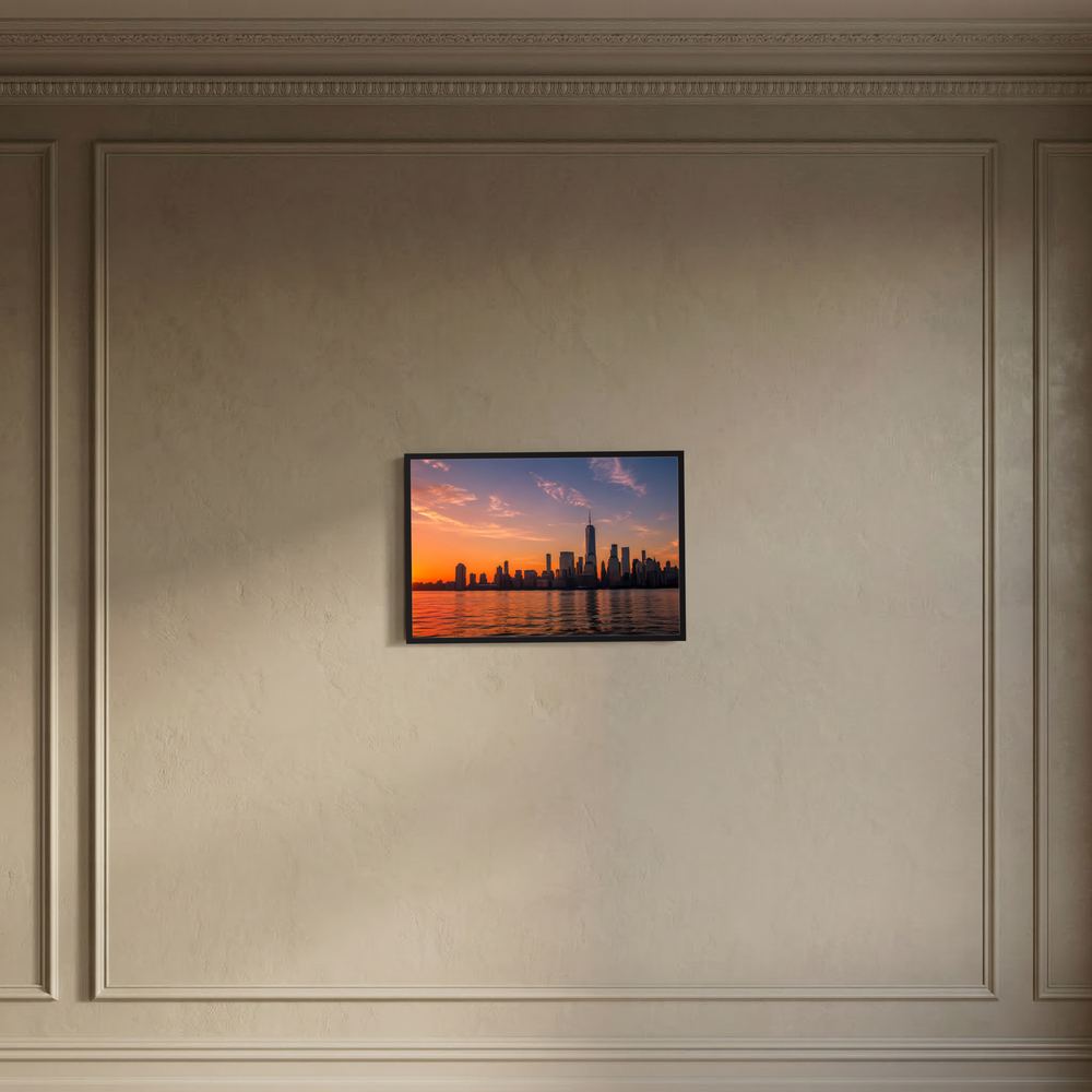 Gerahmtes Poster an der Wand im Querformat mit Skyline bei Sonnenuntergang über Wasser
