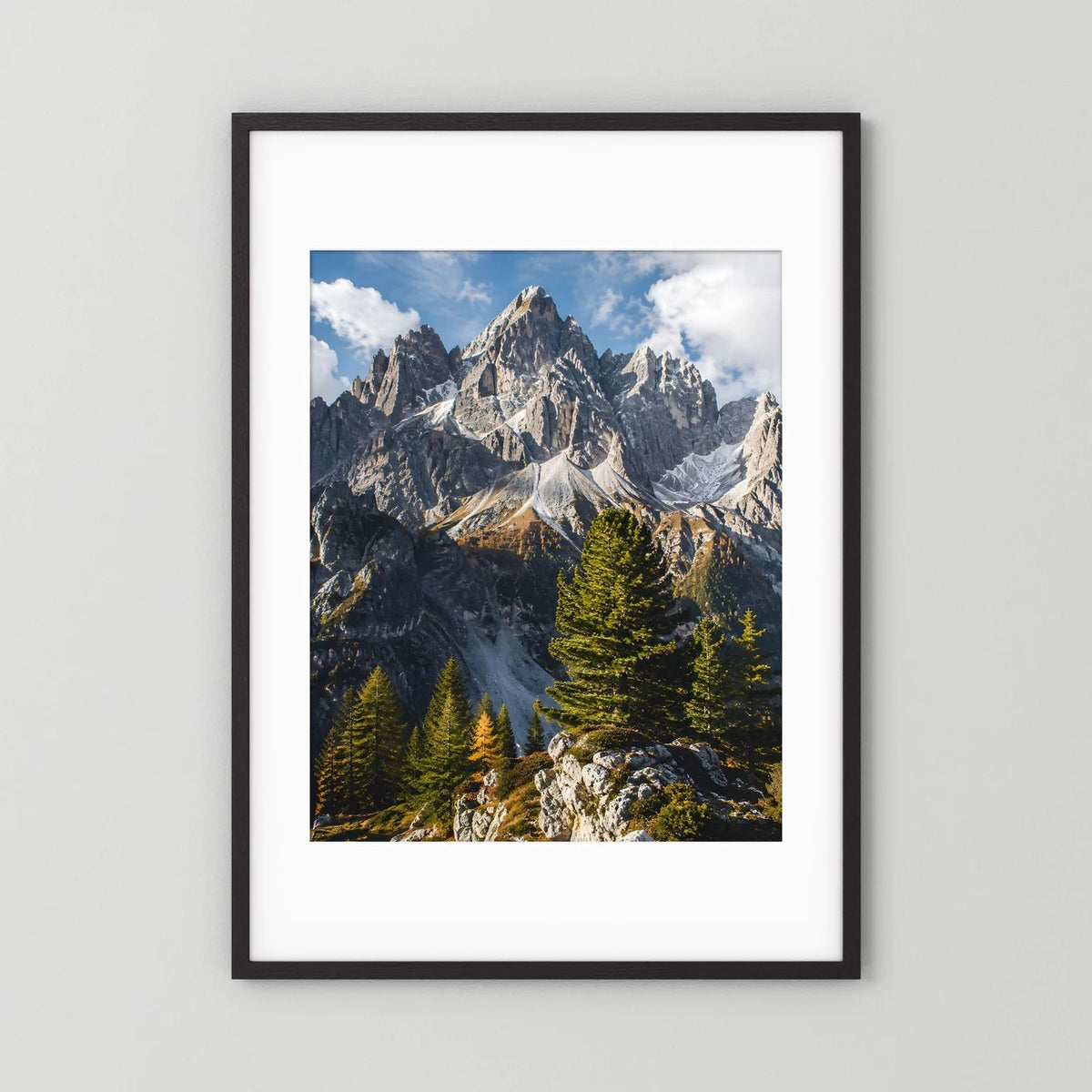 Poster mit schwarzem Holzrahmen und weißem Passepartout: Alpen-Gipfel und Tannen im Hochformat.