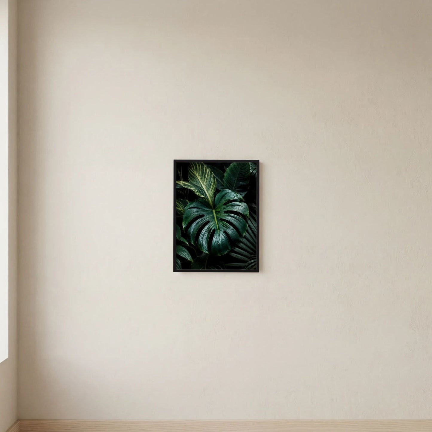 Schwarzer Rahmen mit Postermotiv: dunkle Monstera-Blätter im Hochformat