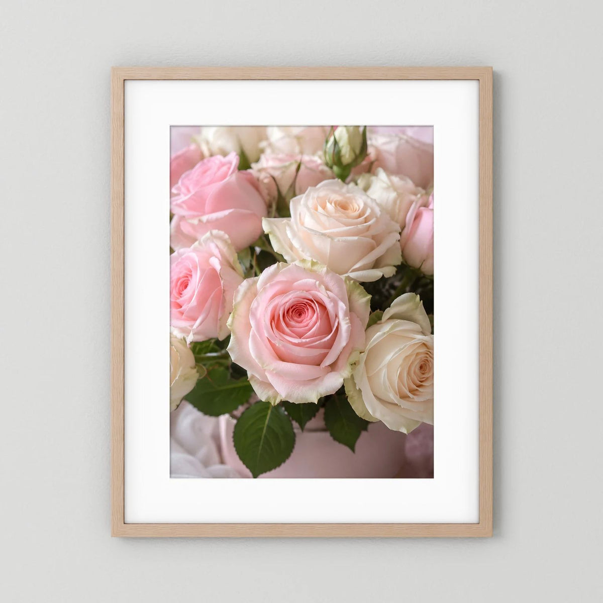 Rosen-Wandposter im hellen Holzrahmen mit rosa und weißen Rosenbouquet.