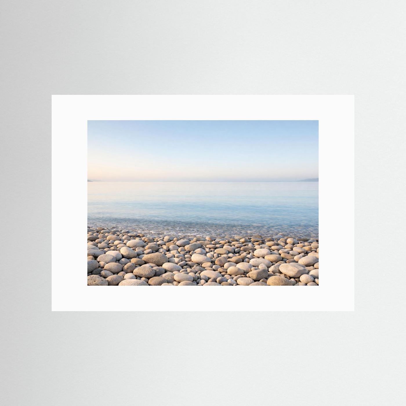 Panorama-Poster im Querformat mit weißem Rand: Steinstrand am ruhigen Meer