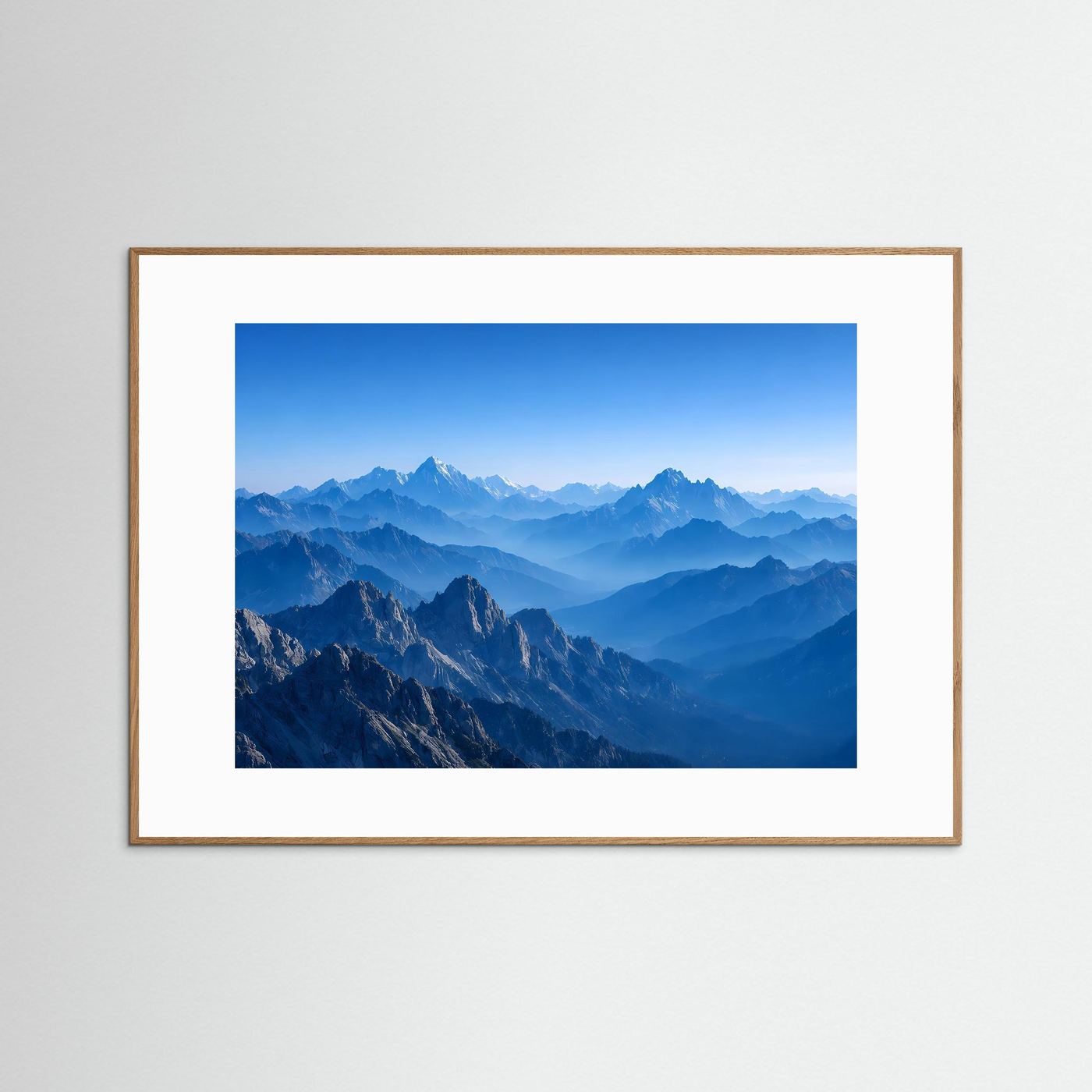 Wandbild mit blauer Berglandschaft im Querformat, hellbrauner Holzrahmen