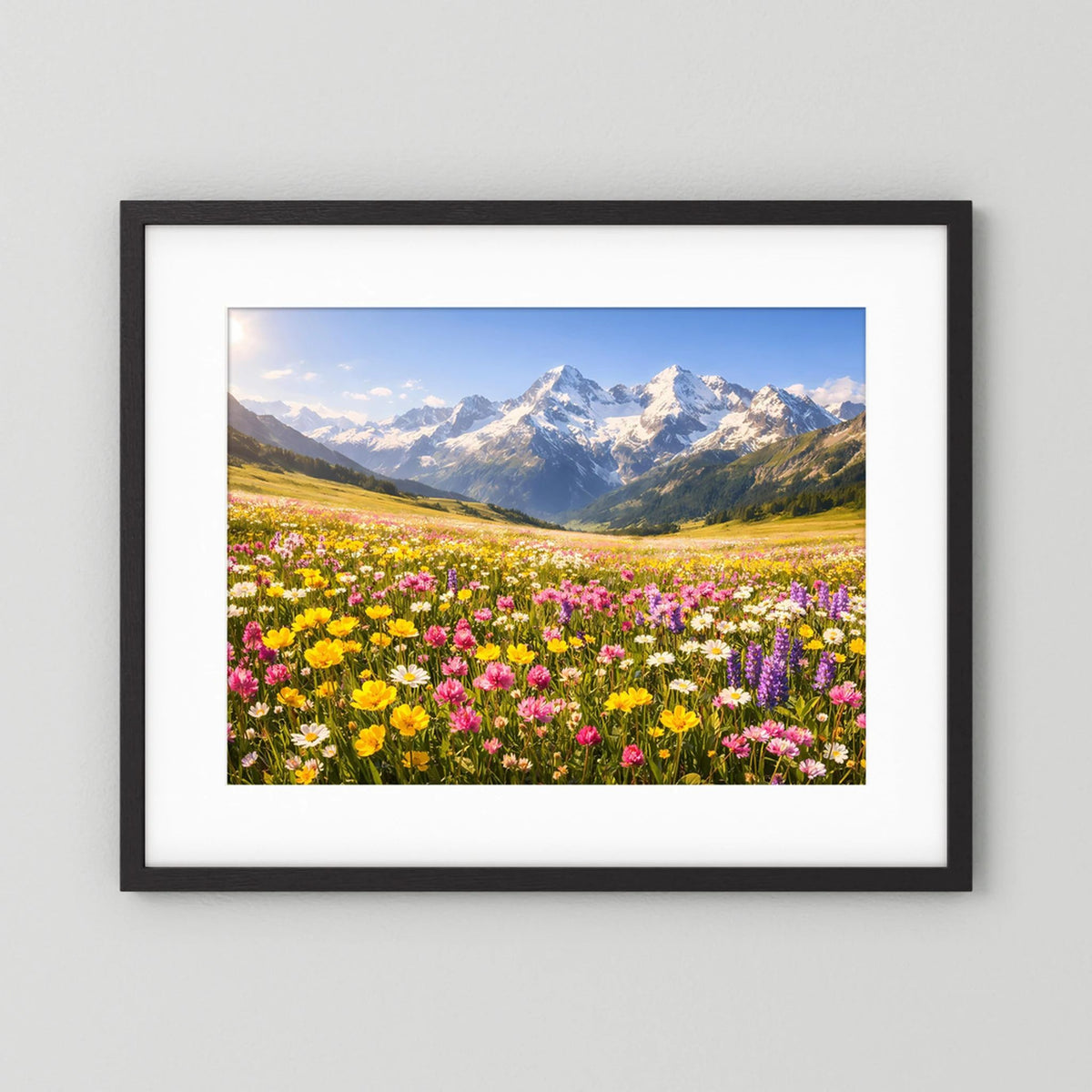 Wandbild mit Alpenblumenwiese und Bergpanorama im schwarzen Rahmen