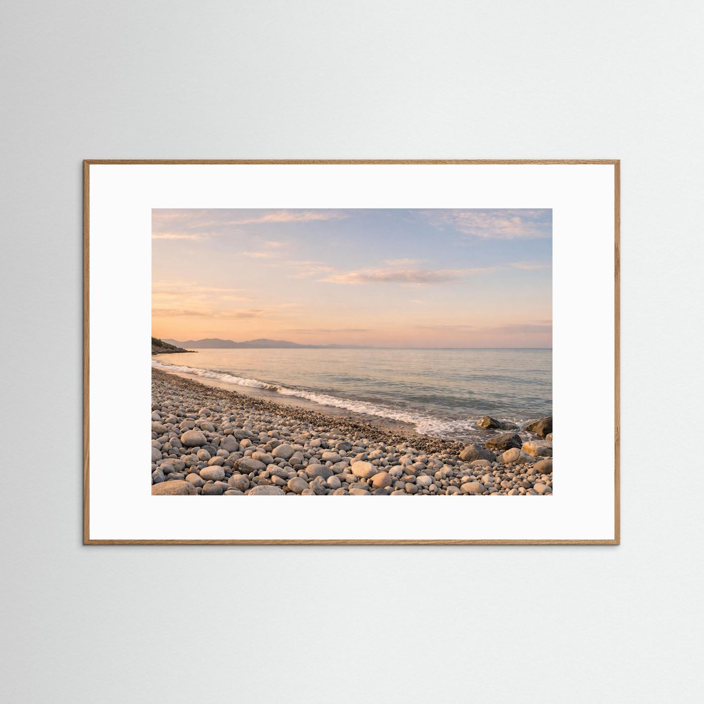 Küsten-Panorama-Poster: Steinstrand, Meer und Dämmerungshimmel, Querformat, mittelbrauner Rahmen