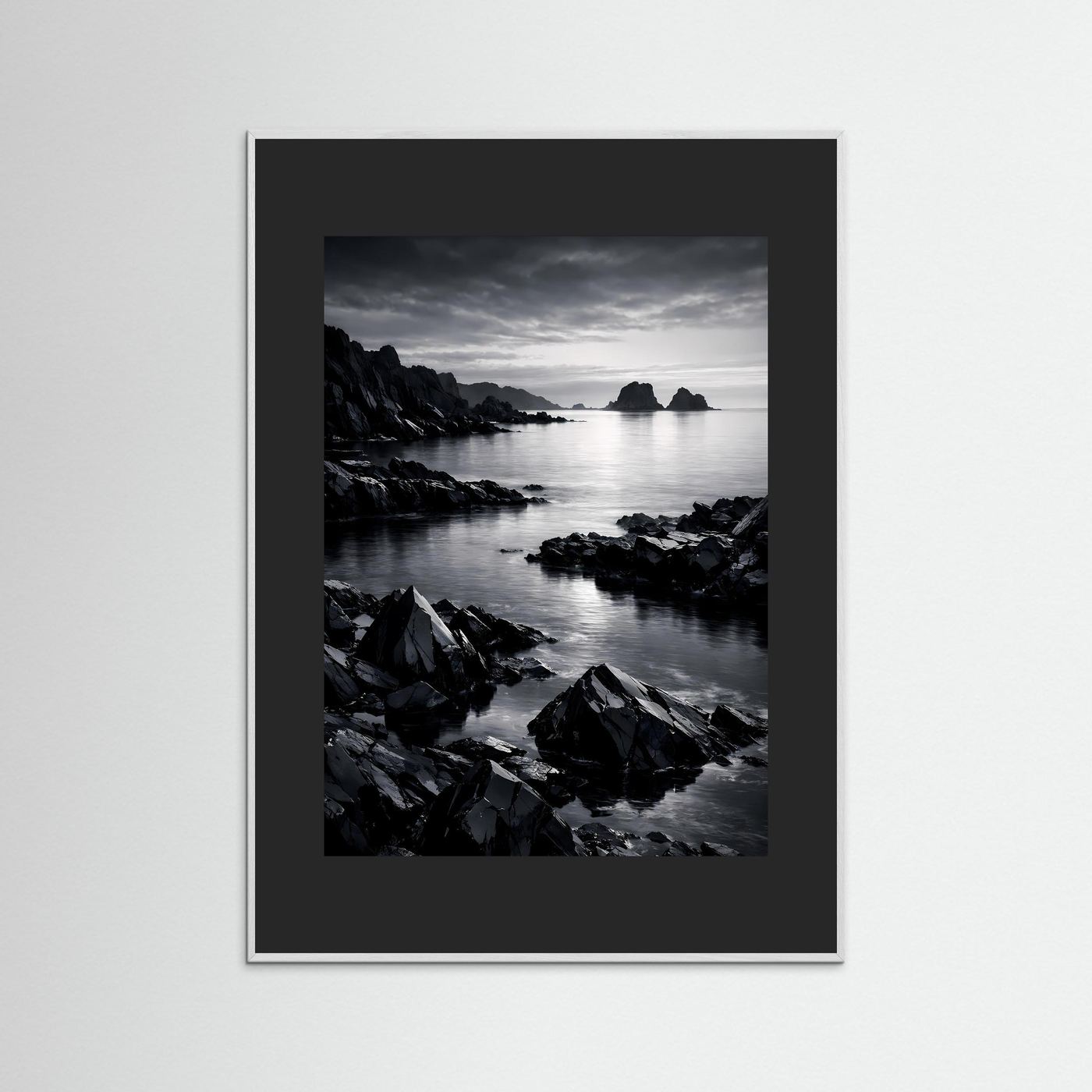 Gerahmtes Schwarzweiß-Foto einer Felsküste am Wasser mit schwarzem Rahmen und Innenrand