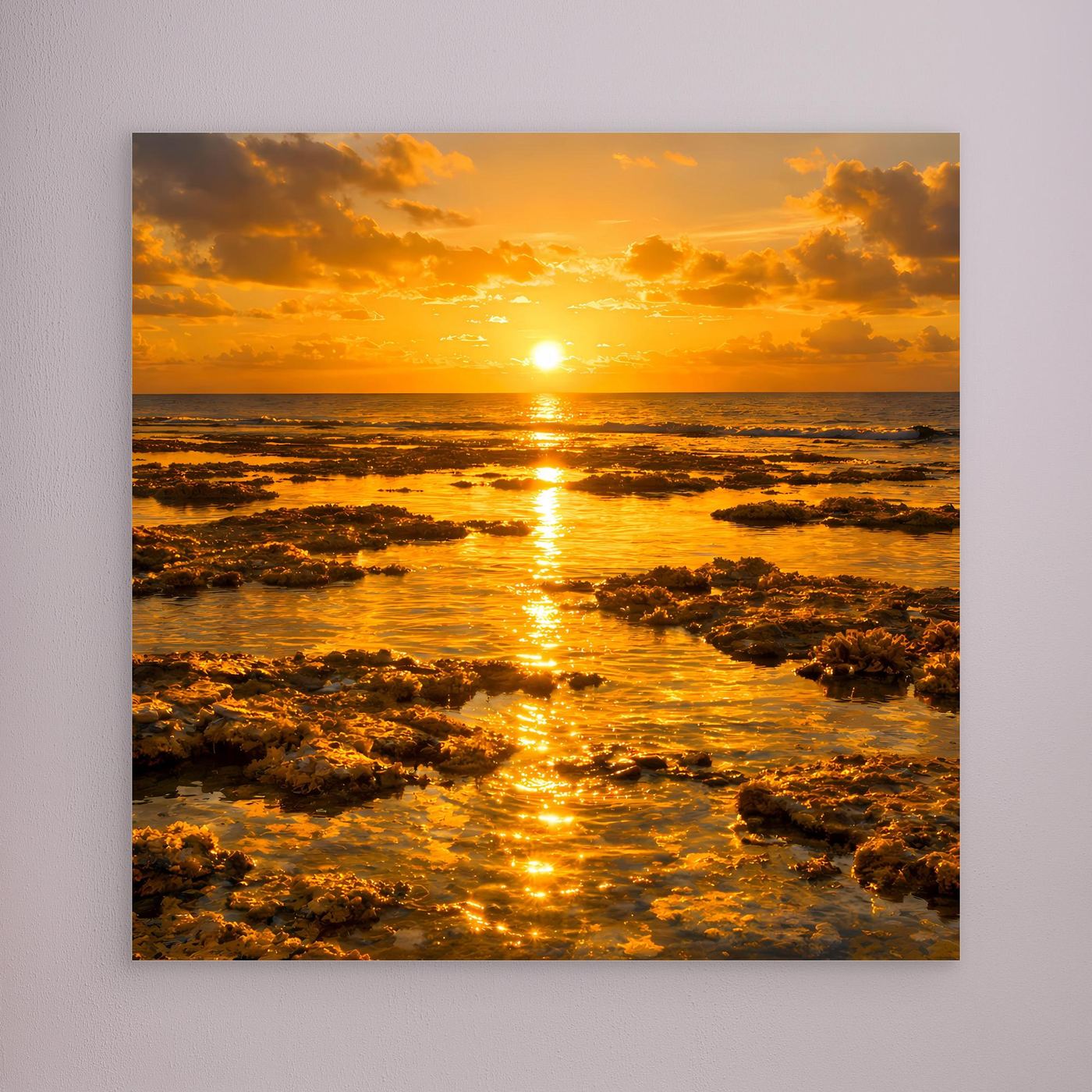Un gerahmtes Leinwandbild mit goldenem Sonnenuntergang am Meer und Felsriffen