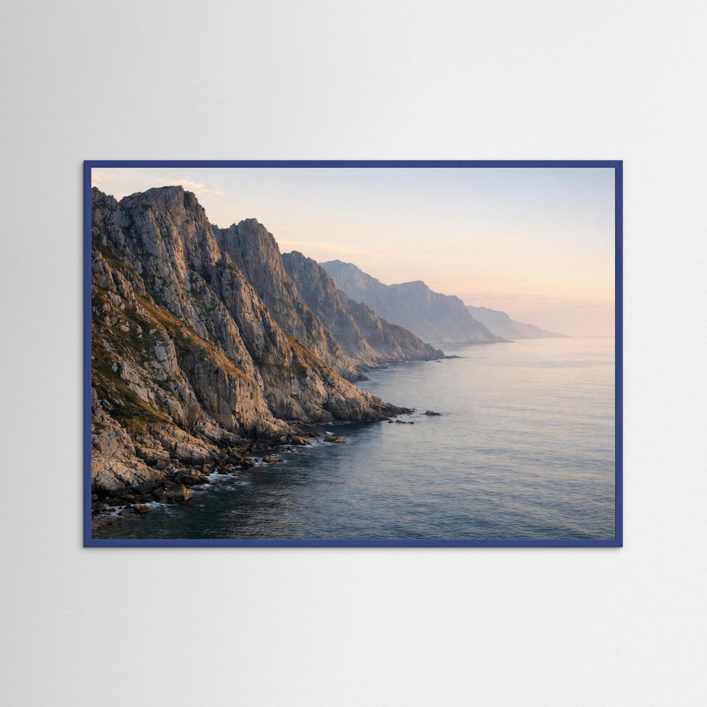 Gerahmtes Poster im Querformat: Panorama-Felsküste am Meer im Abendlicht, blauer Rahmen
