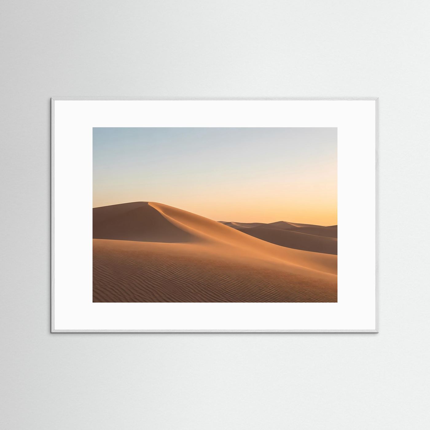 Gerahmtes Wüstenbild mit goldenen Dünen im Sonnenuntergang, weißer Rahmen