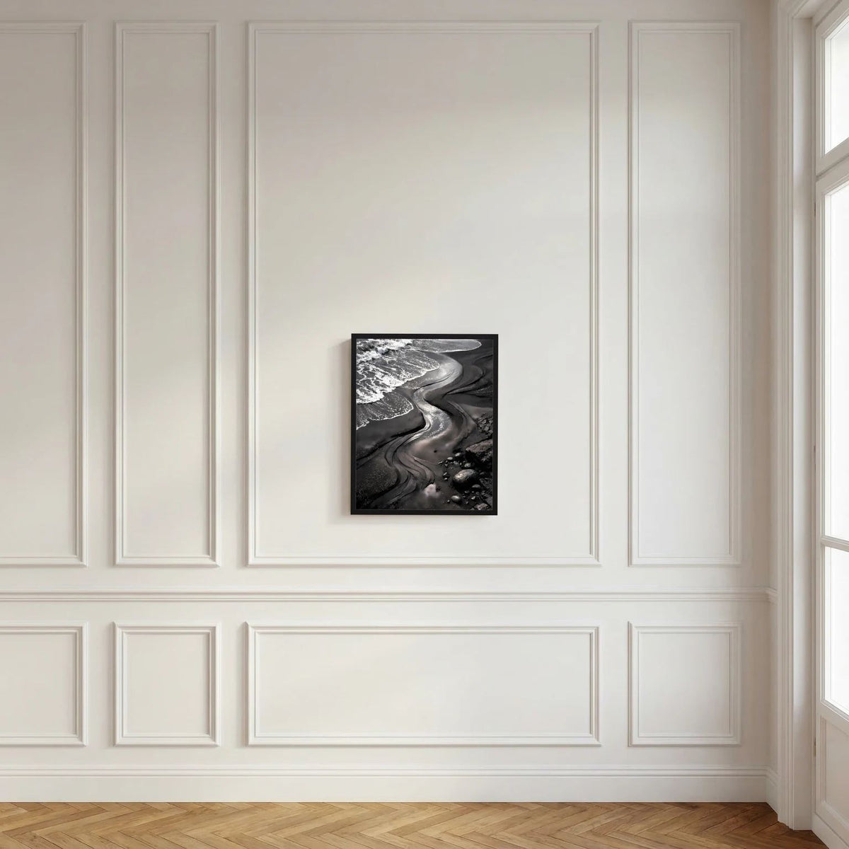Strandposter im schwarzen Rahmen mit schwarzen Meereswellen in heller Wandverkleidung
