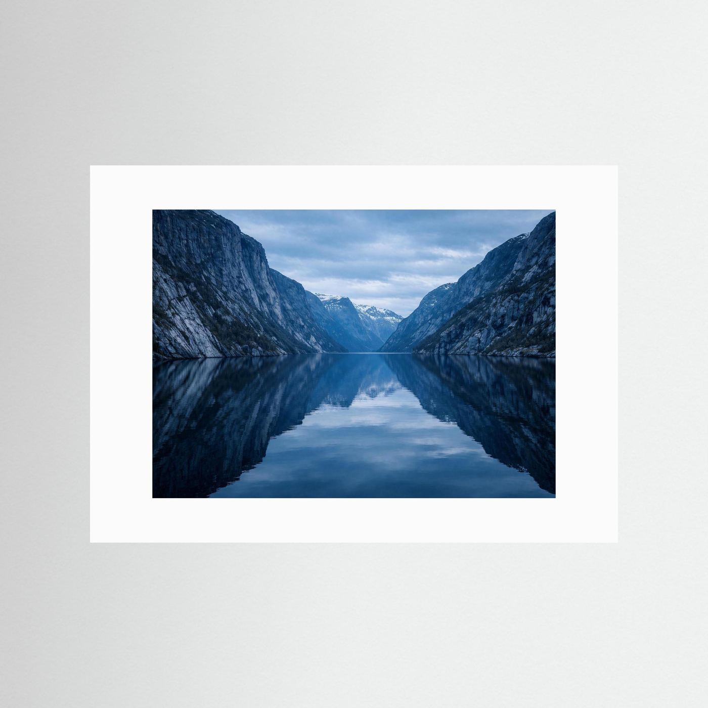Panorama-Poster mit weißem Rand: Fjordspiegelung zwischen blauen Bergen, querformat