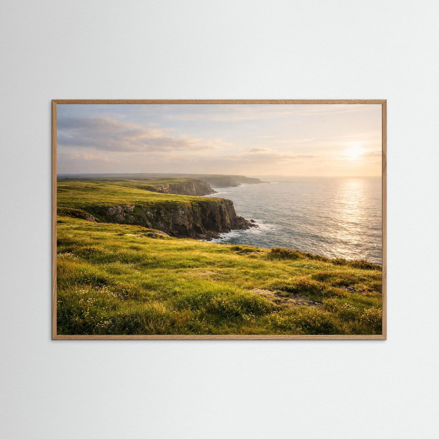 Querformat-Poster: grüne Klippen am Meer bei Sonnenuntergang, hellbrauner Rahmen