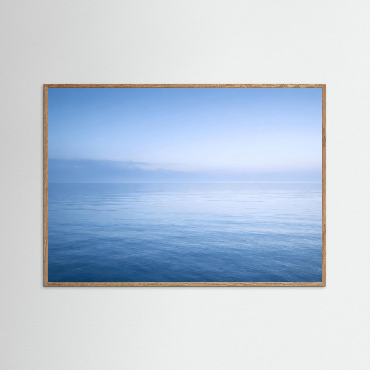 Meer-Wandbild Querformat mit hellem Holzrahmen, Horizont über ruhigem Meer im Blau.