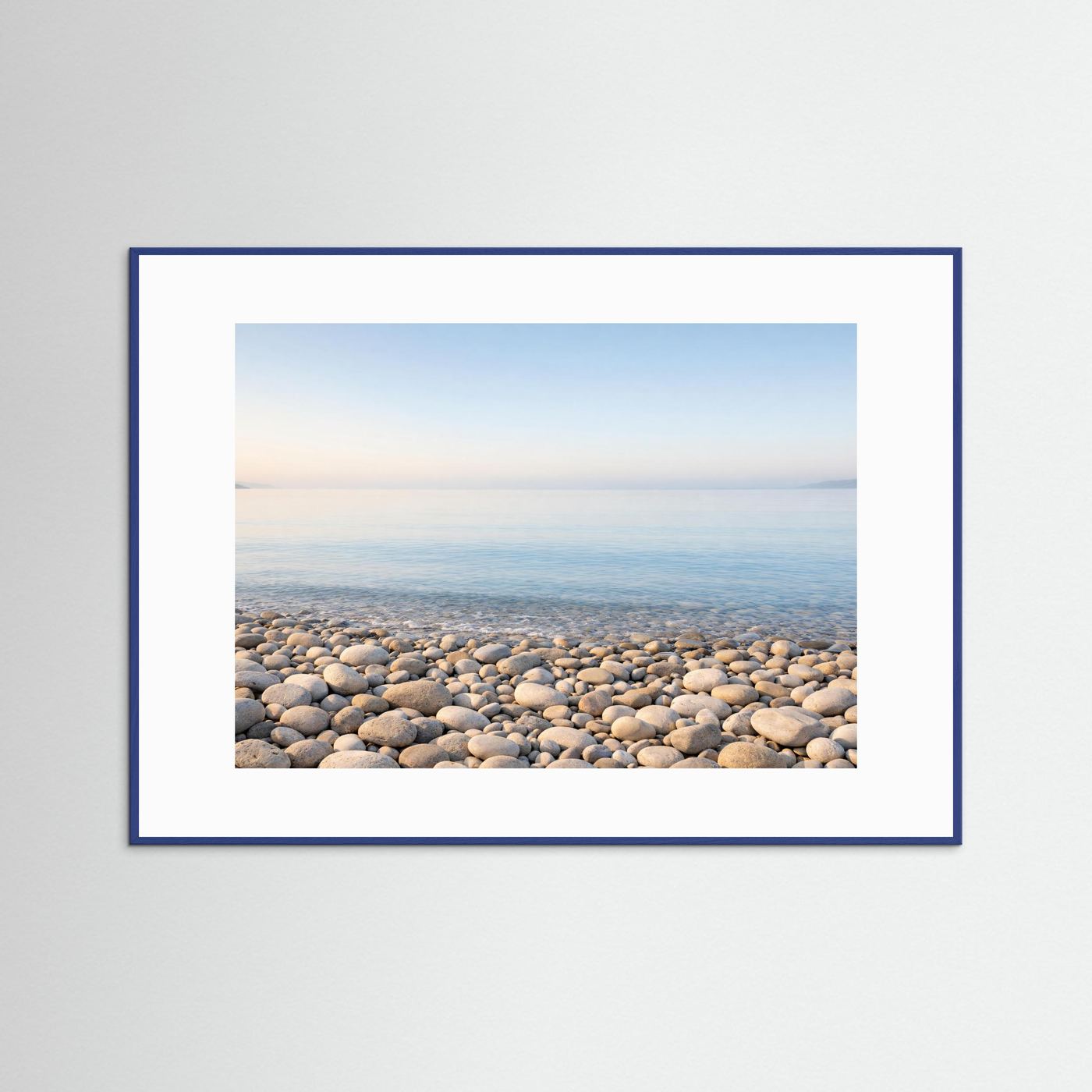 Küsten-Panorama-Poster mit Kiesstrand und ruhigem Meer, blauer Rahmen