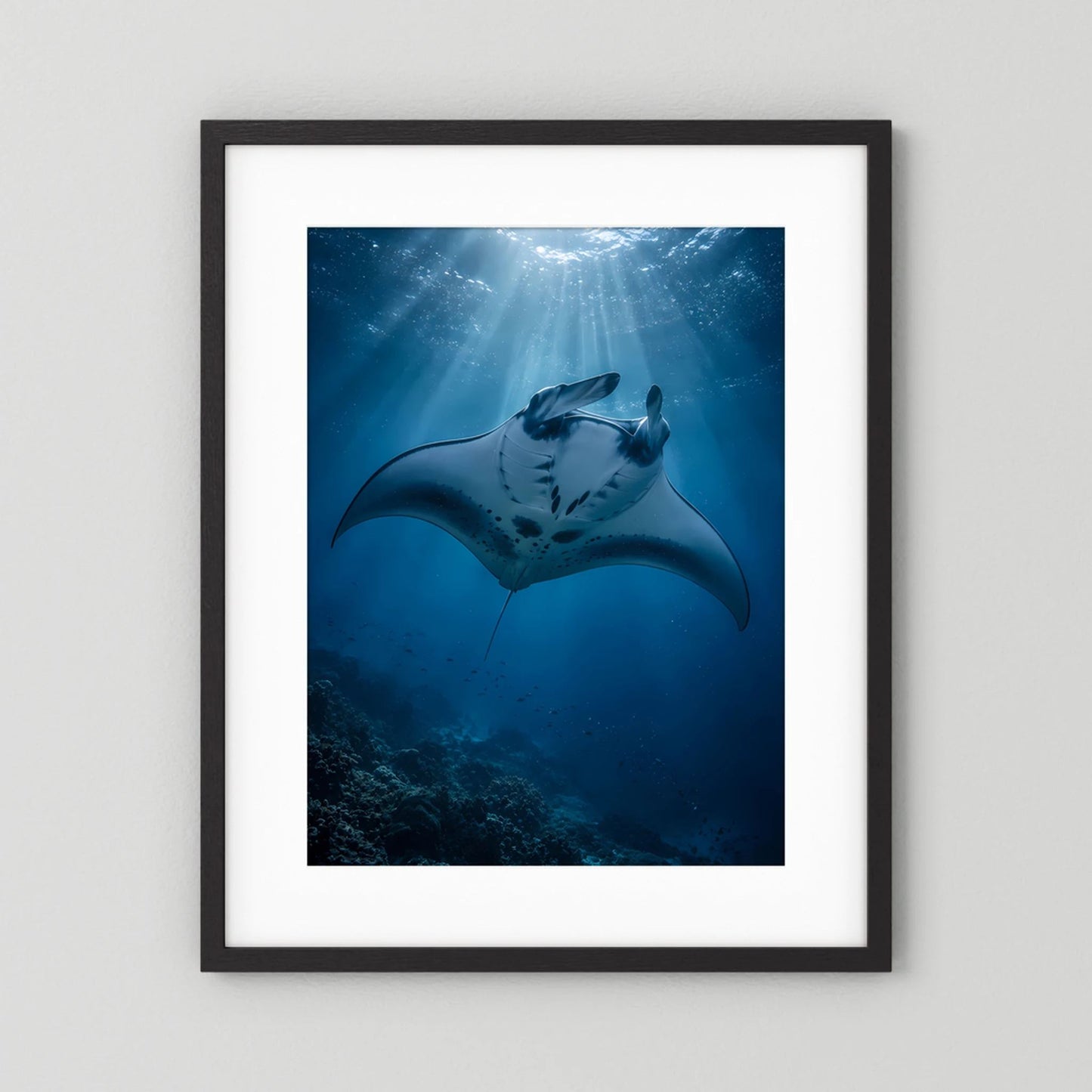 Gerahmtes Hochformat-Poster mit Mantarochen im tiefblauen Ozean, Lichtstrahlen, schwarzer Rahmen