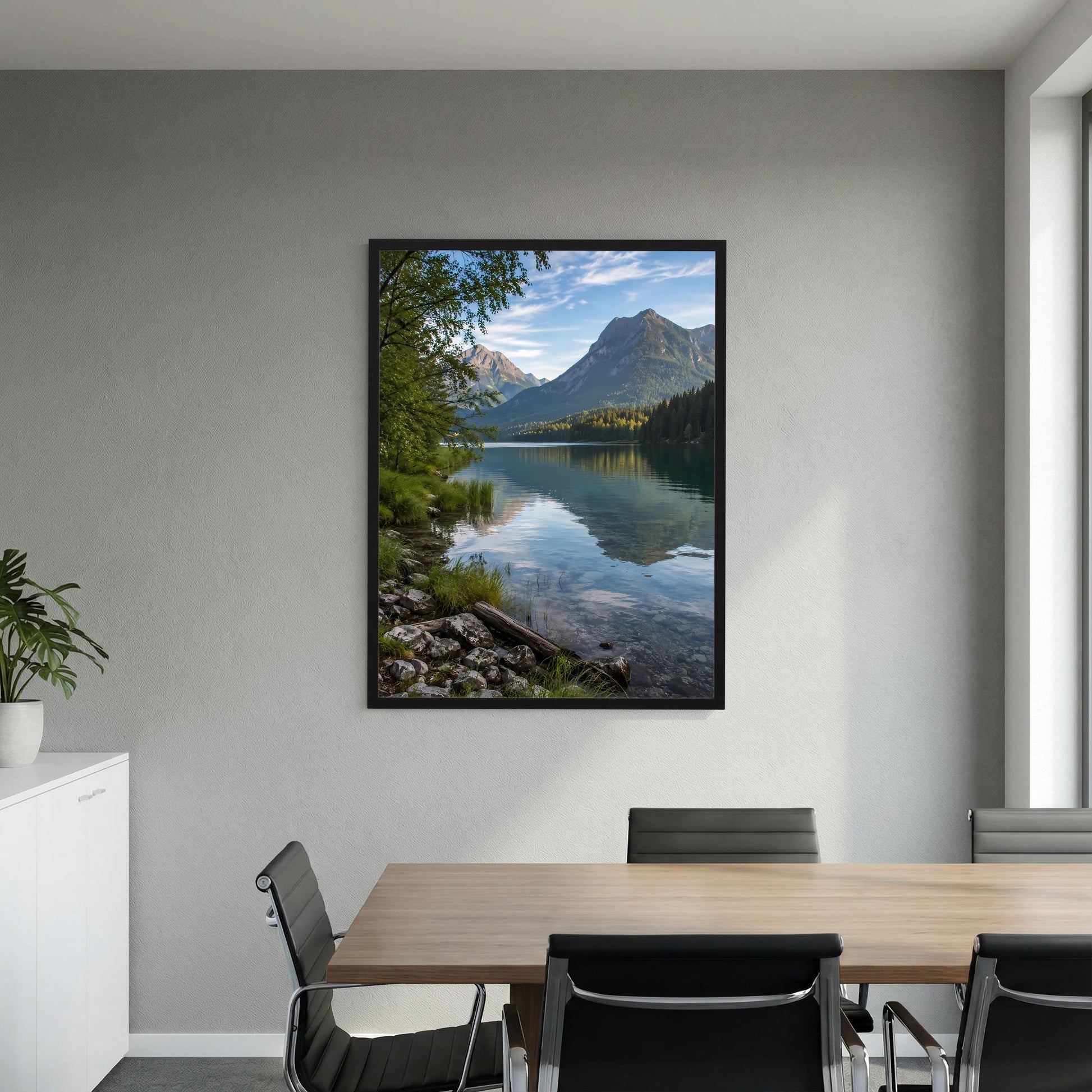 Poster im schwarzen Rahmen mit Alpensee und Bergen an der Wand über dem Konferenztisch