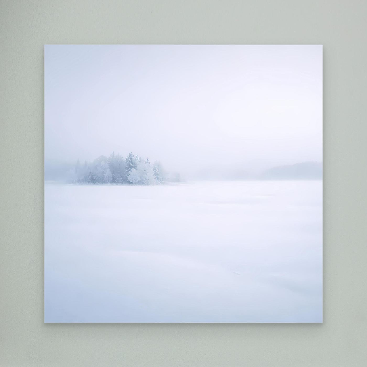Leinwandbild mit Wintersee-Motiv: verschneite Bäume im Nebel, ruhige helle Flächen