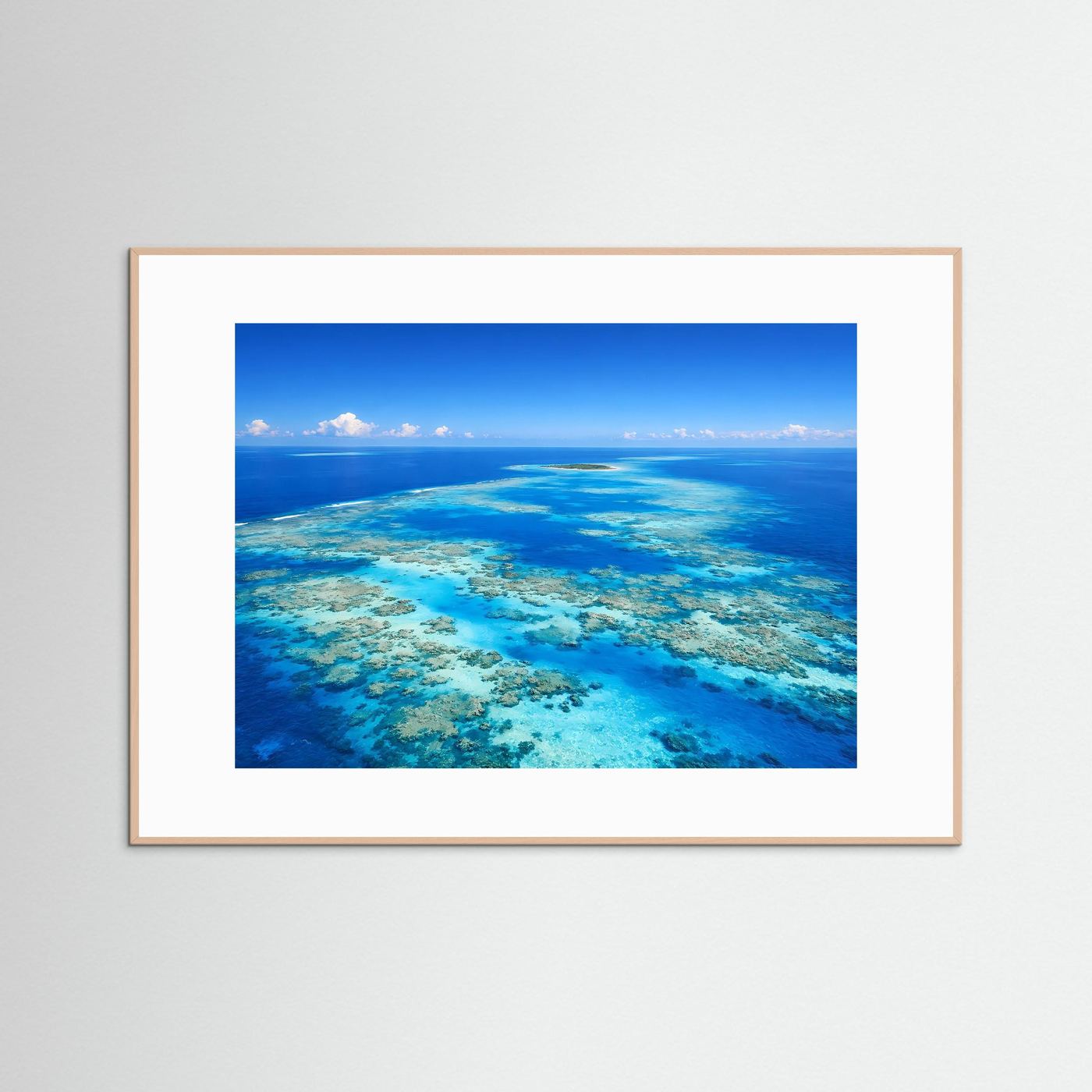 Wandbild mit Korallenriff im türkisblauen Meer, heller Holzrahmen und weißer Rand
