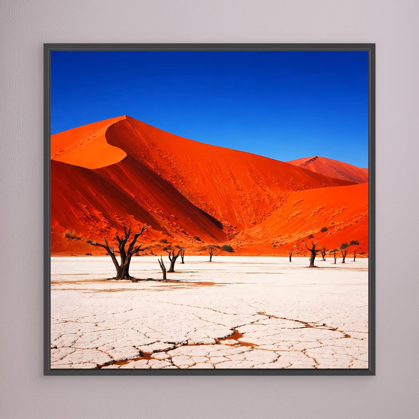 Leinwandbild mit roten Dünen, Rissboden und Bäumen, schwarz eingefasst.