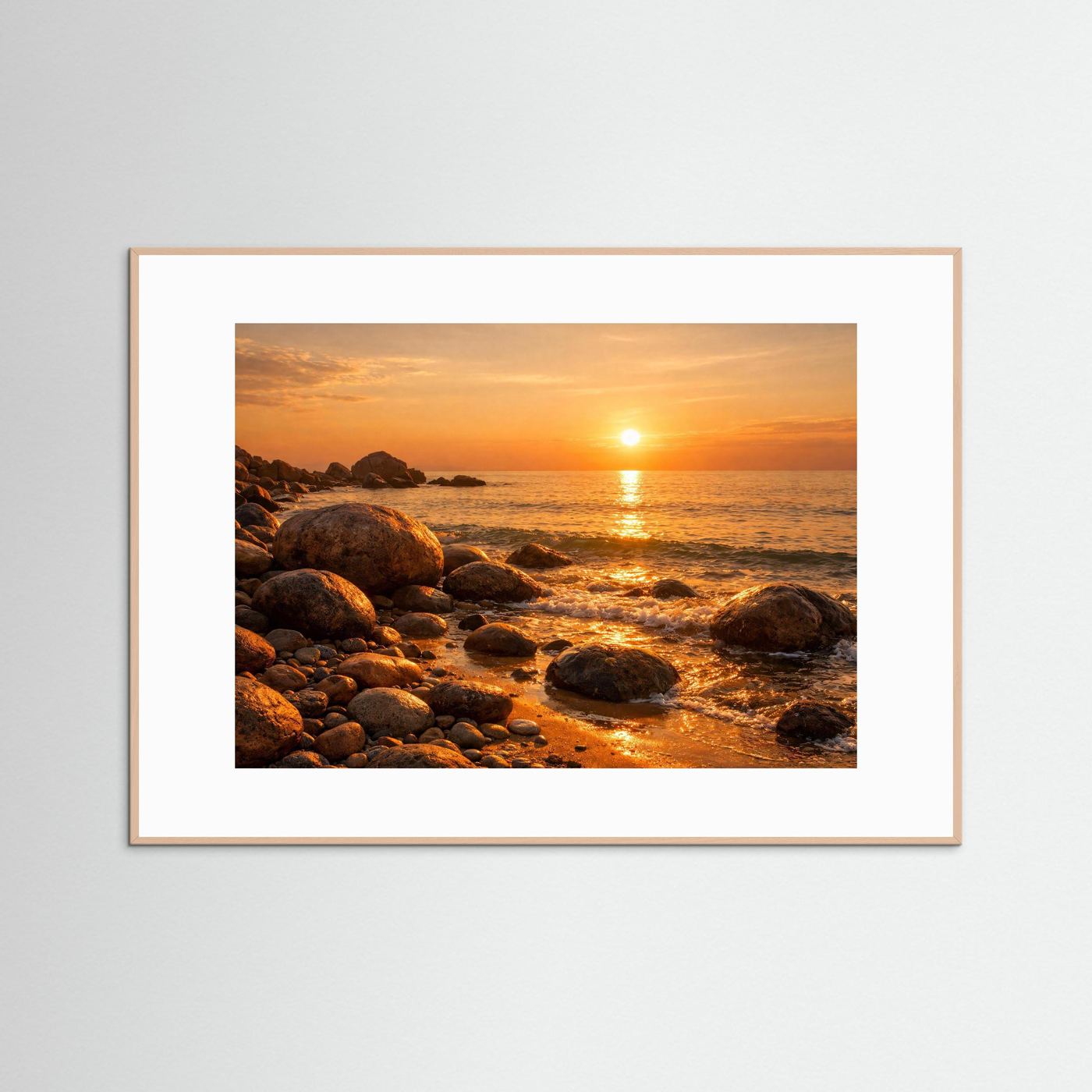 Gerahmtes Poster mit hellem Rahmen: Sonnenuntergang am Felsenstrand, Wellen und Steine am Ufer.